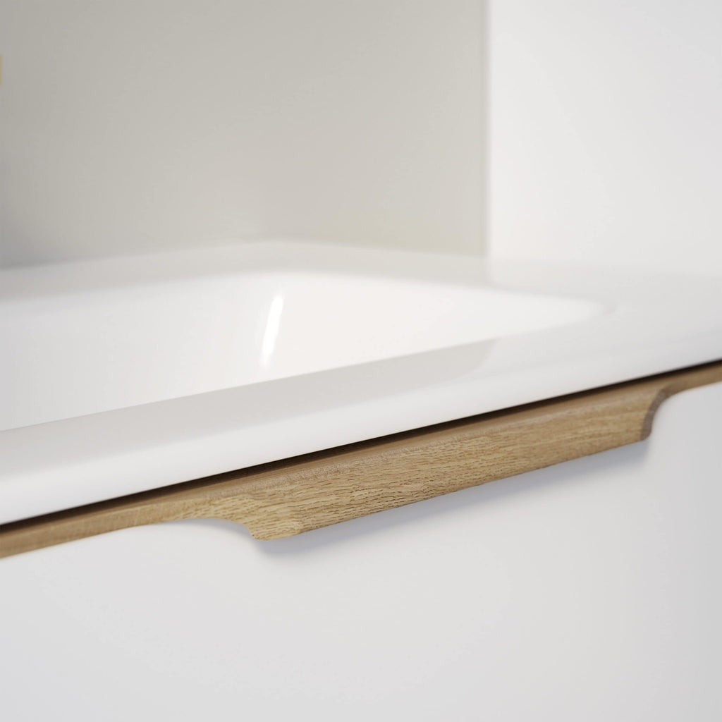 Shaker kitchen cabinet with white finish and natural wood accents, featuring a stylish curved wooden handle for a modern, minimalist bathroom or kitchen design.