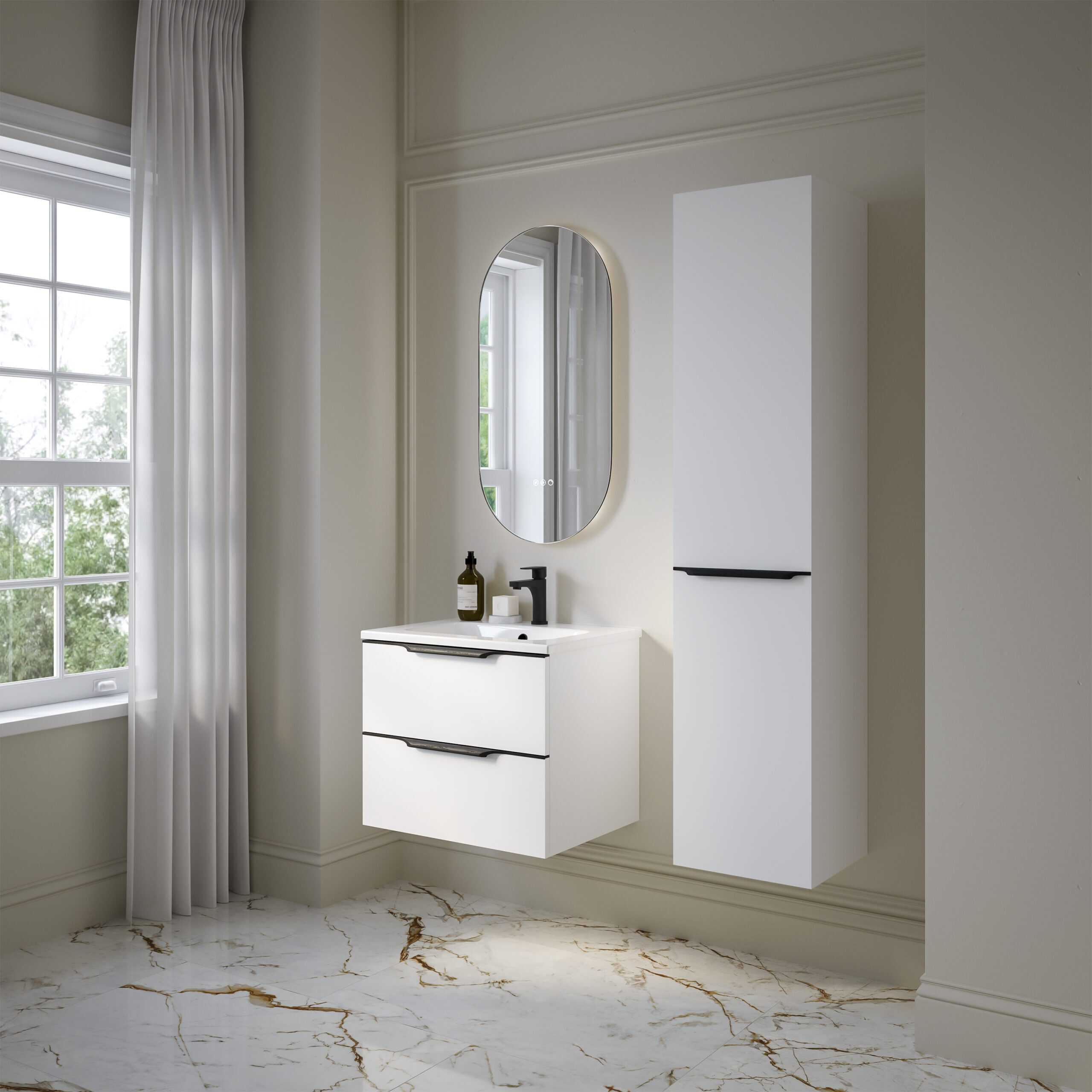 Modern white bathroom vanity unit with dual drawers, sleek black handles, and a compact black faucet, complemented by an oval mirror and tall storage cabinet in a bright, minimalist bathroom setting.