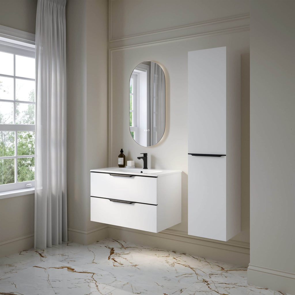 Modern white bathroom vanity with black handles, oval mirror, and sleek black faucet in a bright, elegant bathroom setting with marble flooring and large window.