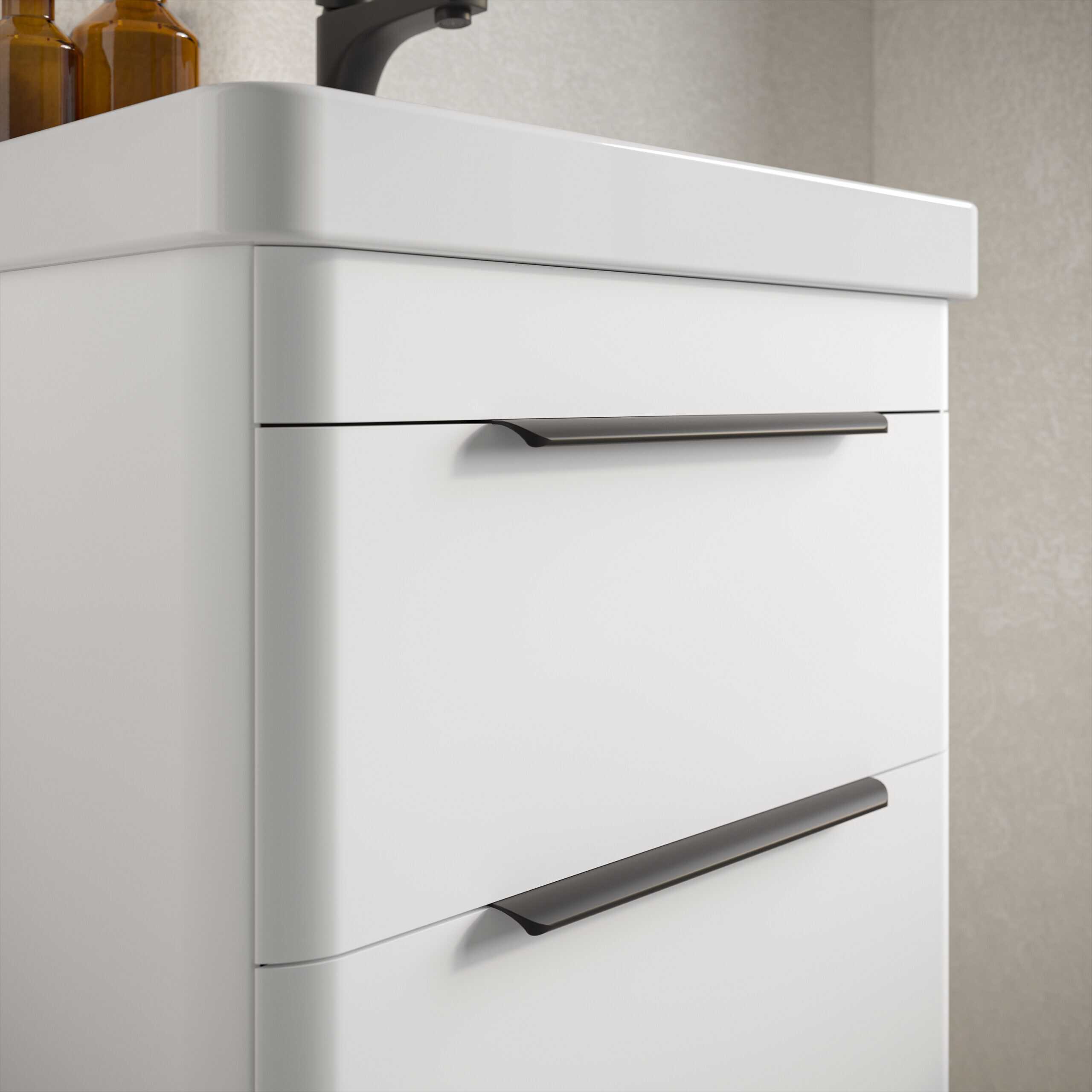 White bathroom vanity unit with sleek black handles for modern bathroom storage solutions.