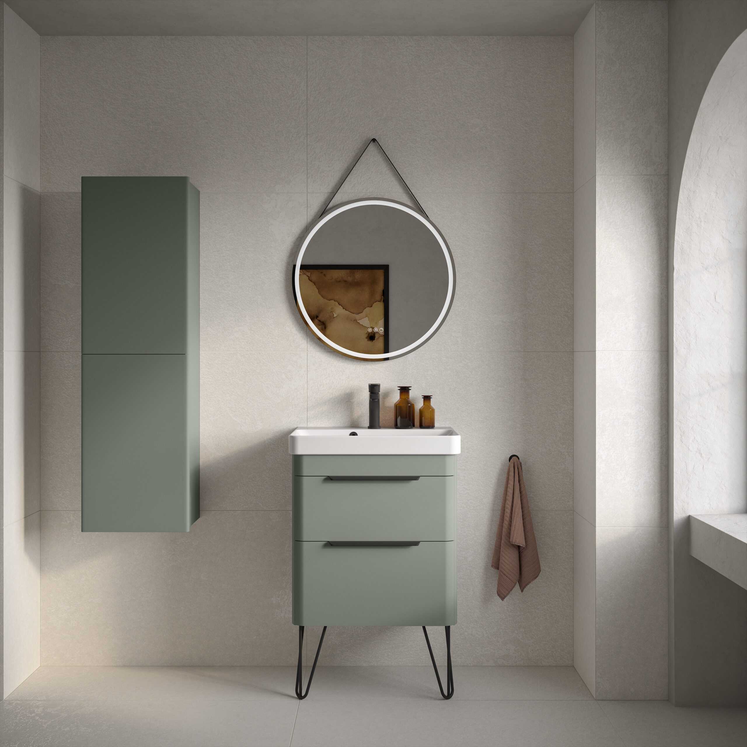 Sleek green bathroom vanity with matching wall cabinet, modern round mirror, and minimalist accessories creating a contemporary and stylish bathroom space.