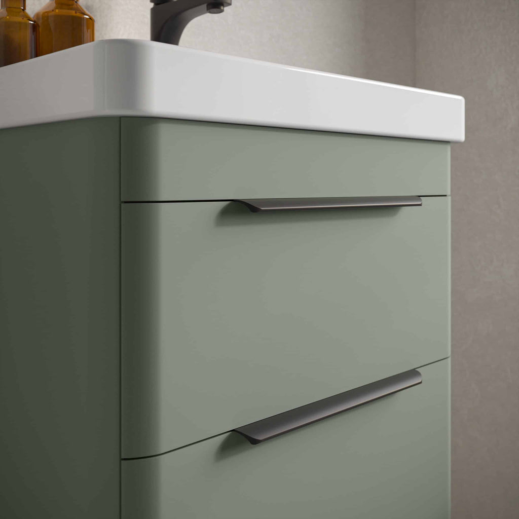 Sleek green bathroom cabinet with modern black handles, providing stylish storage solutions for bathroom organisation and design.