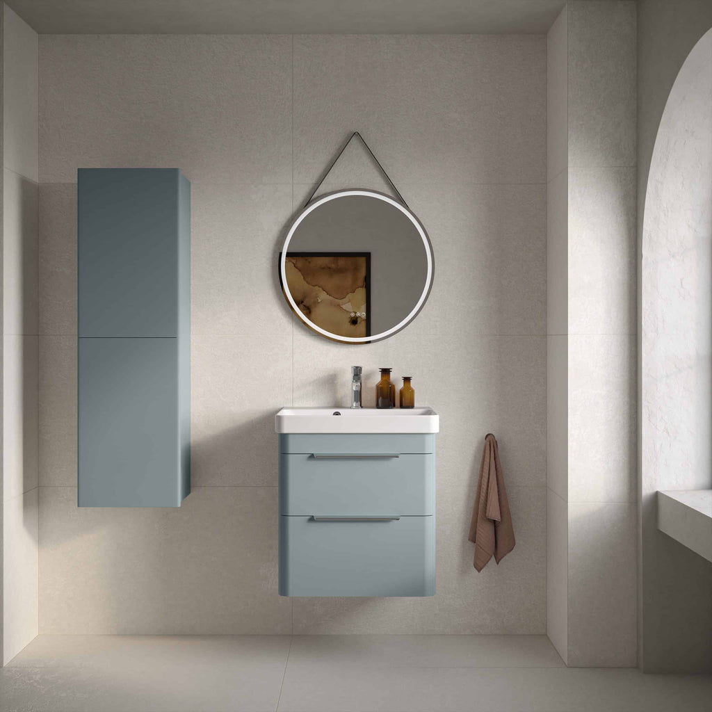 Sleek blue wall-mounted bathroom vanity with integrated sink, circular mirror with LED lighting, and matching storage cabinet in a modern, minimalist bathroom setting.