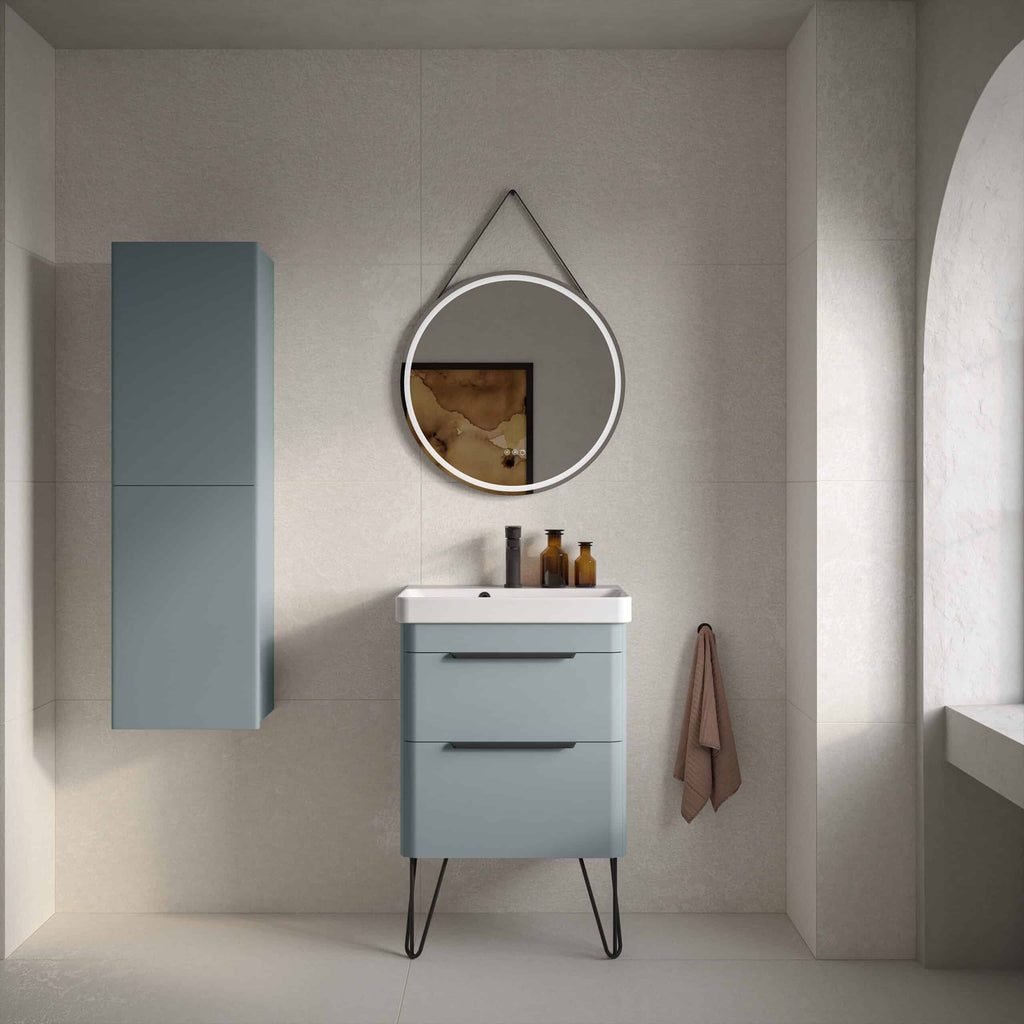 Sleek modern blue bathroom vanity with matching wall cabinet, round mirror with LED lighting, and black fixtures, creating a minimalist and stylish bathroom space.