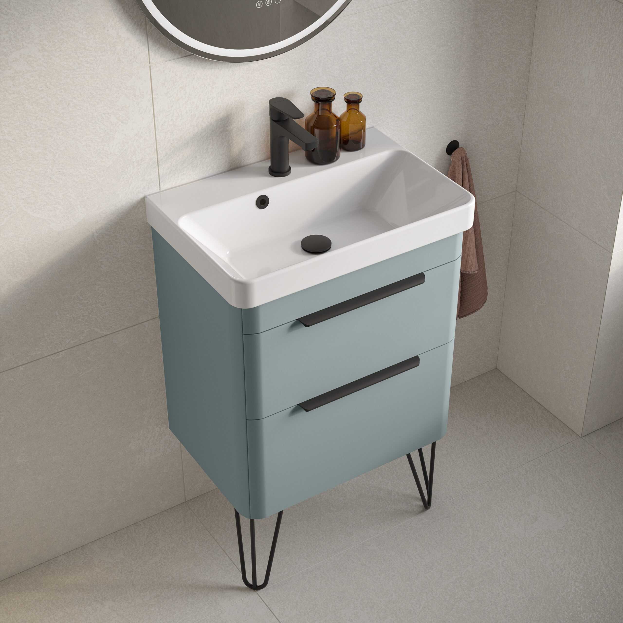 Modern bathroom vanity unit with integrated sink in soft blue colour and black metal hairpin legs, featuring sleek black handles and accessories for contemporary bathroom decor.