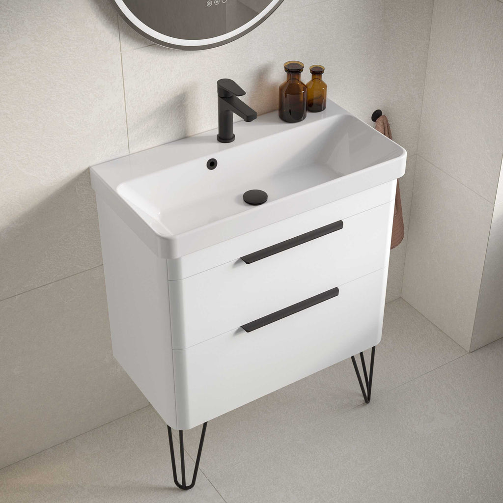 Minimalist white bathroom vanity with black handles and hairpin legs perfect for modern design. Features two spacious drawers, black tap, and accessories for stylish bathroom storage.