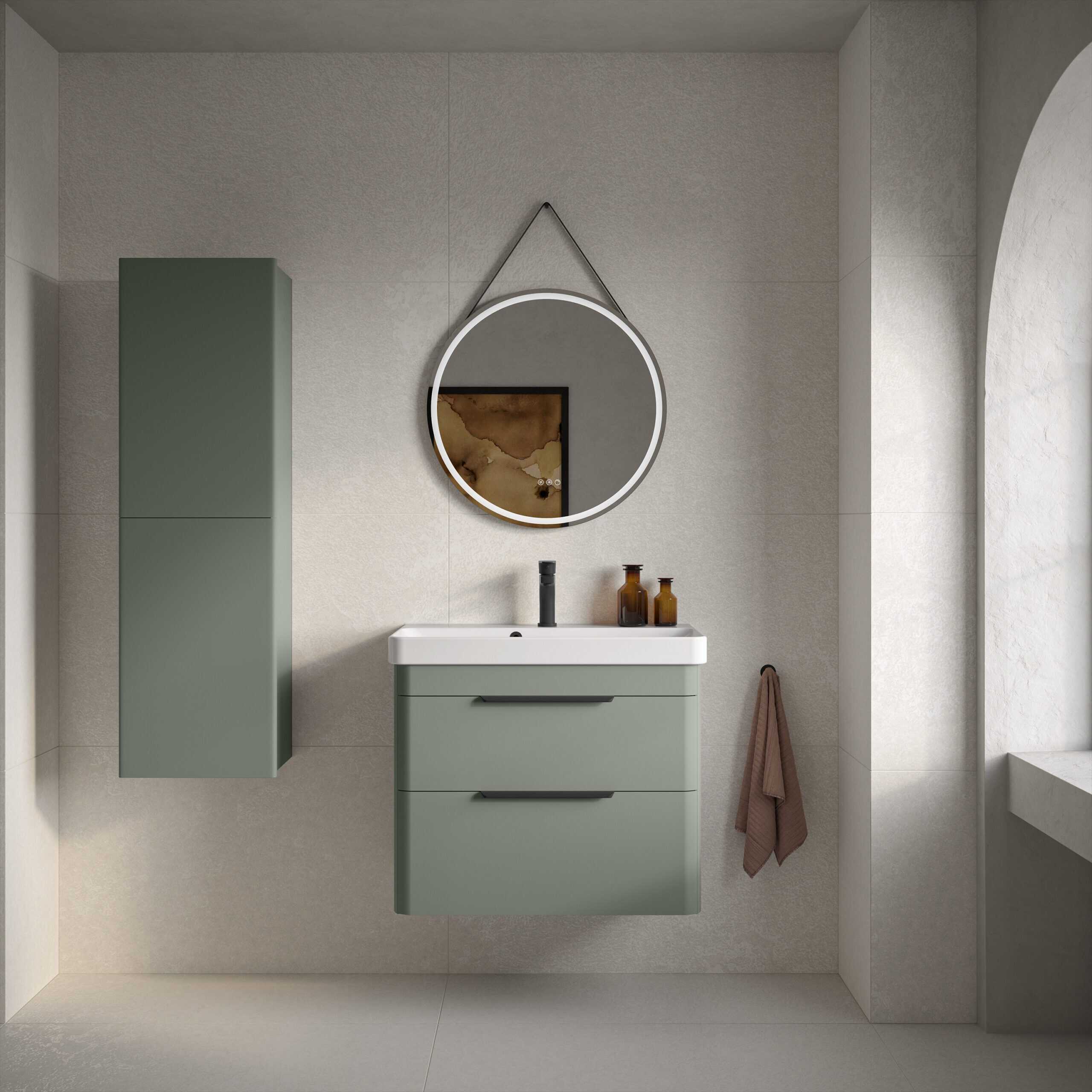 Sleek green bathroom vanity unit with a matching wall-mounted cabinet, modern round mirror with LED lighting, brown glass bottles, and a soft brown towel, creating a minimalist and contemporary bathroom design.