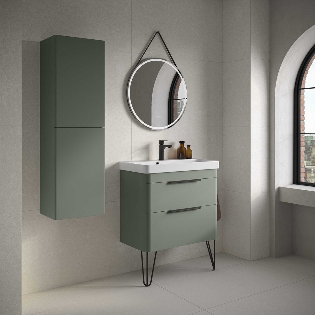 Modern green bathroom vanity with sleek drawers and black handles, wall-mounted cabinet, round mirror with LED lighting, and black tap, in a contemporary minimalist bathroom with large arched window.