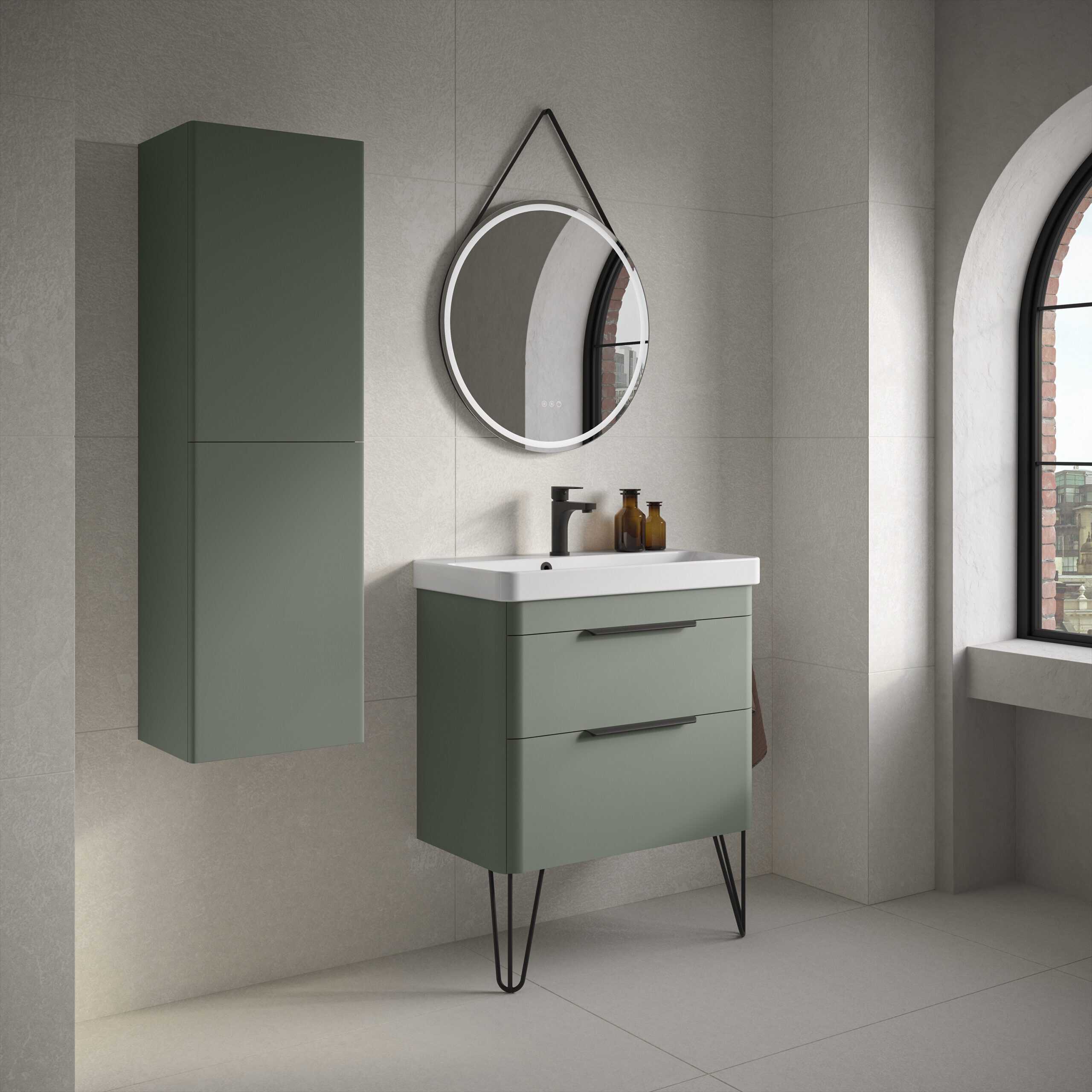 Modern green bathroom vanity with sleek drawers and black handles, wall-mounted cabinet, round mirror with LED lighting, and black tap, in a contemporary minimalist bathroom with large arched window.
