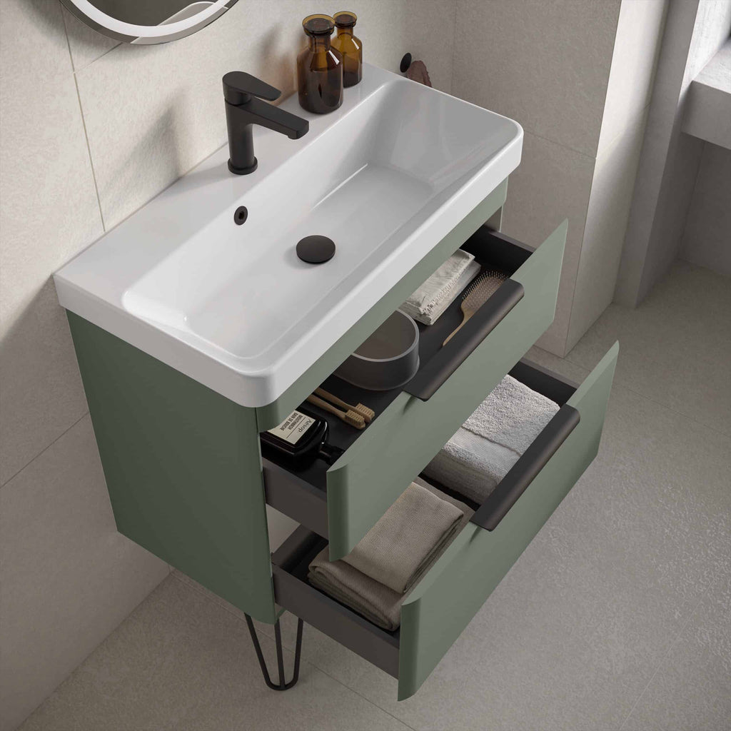 Modern bathroom vanity with sink and storage drawers in muted green, black hardware, and minimalist design, set against neutral tiled walls and flooring, perfect for contemporary bathroom decor.