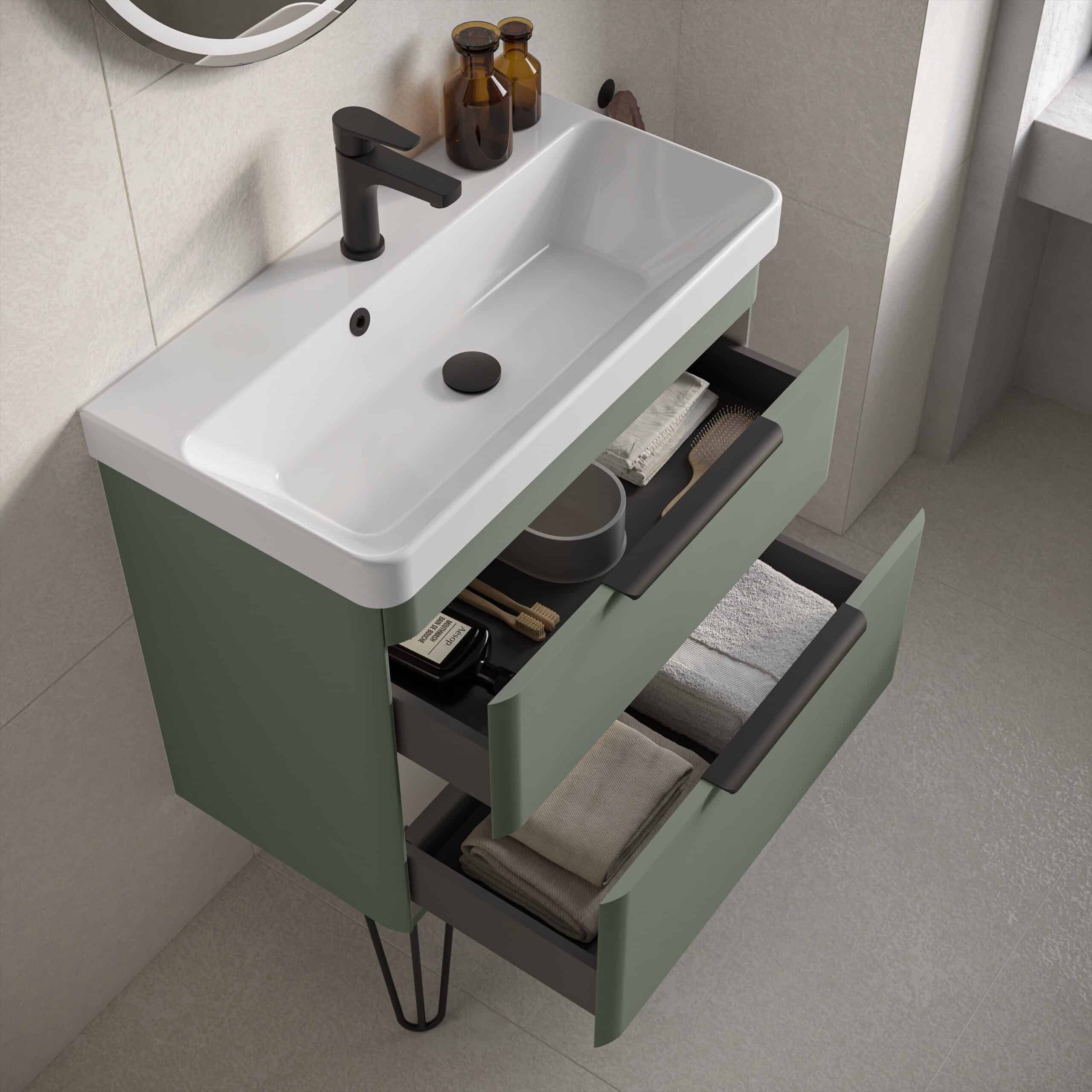 Modern bathroom vanity with sink and storage drawers in muted green, black hardware, and minimalist design, set against neutral tiled walls and flooring, perfect for contemporary bathroom decor.