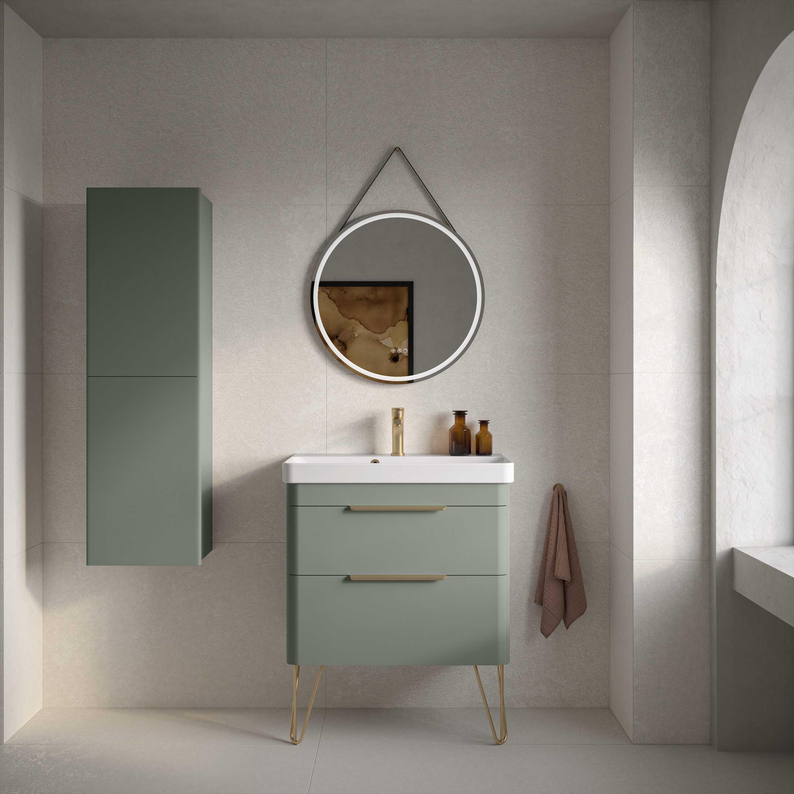 Sleek green bathroom vanity with modern gold handles, matching wall-mounted cabinet, round illuminated mirror, and minimal decor in a contemporary bathroom setting.