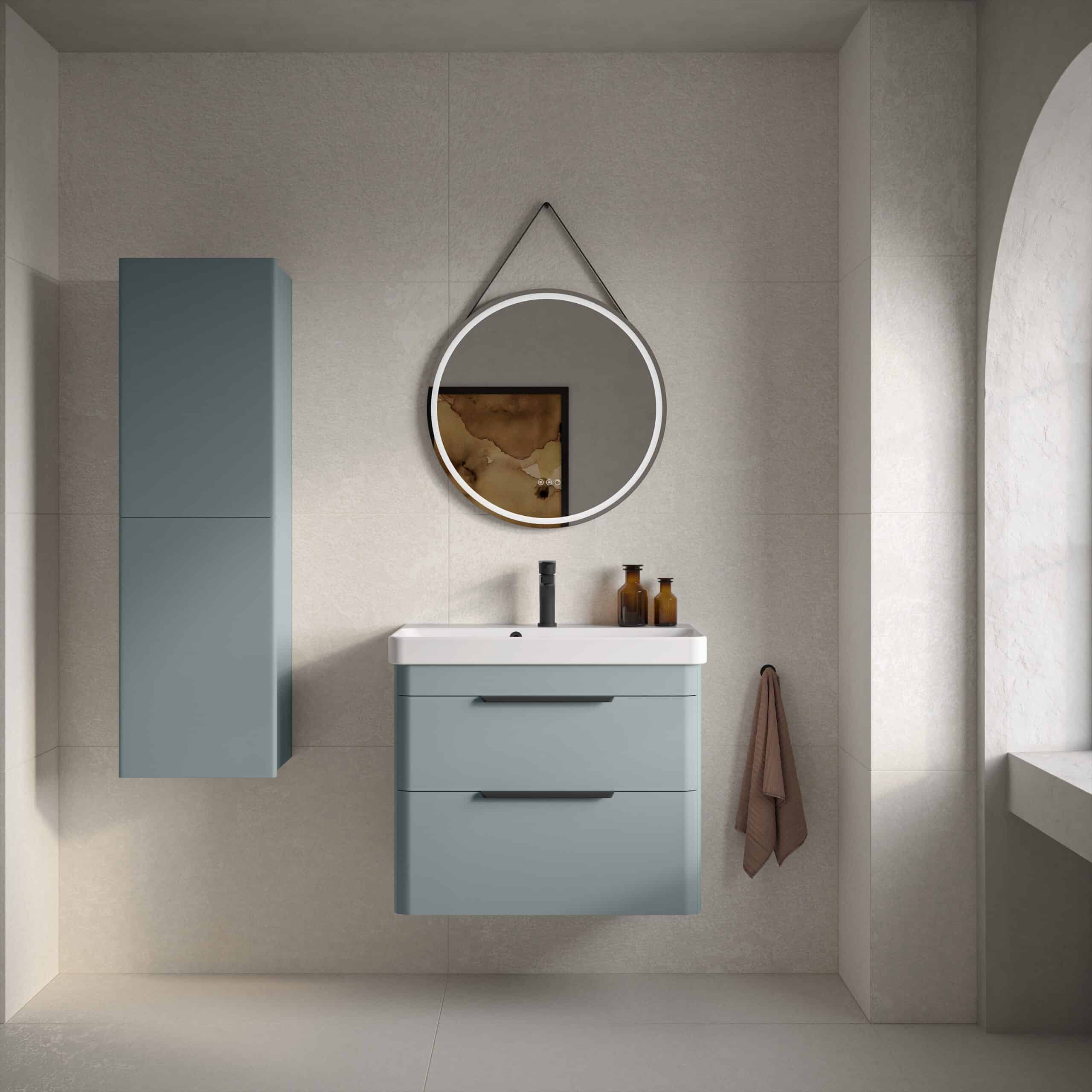 Contemporary blue bathroom vanity set with wall-mounted cabinet, round mirror with LED lighting and modern accessories in a minimalistic bathroom interior.
