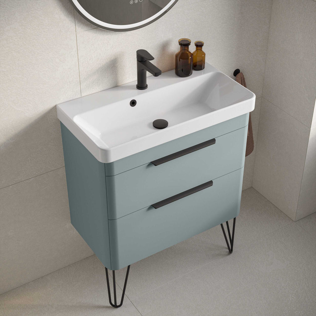 Modern bathroom vanity with integrated sink, black faucet, and storage drawers, featuring sleek, minimalist design in soft blue with black metal hairpin legs.