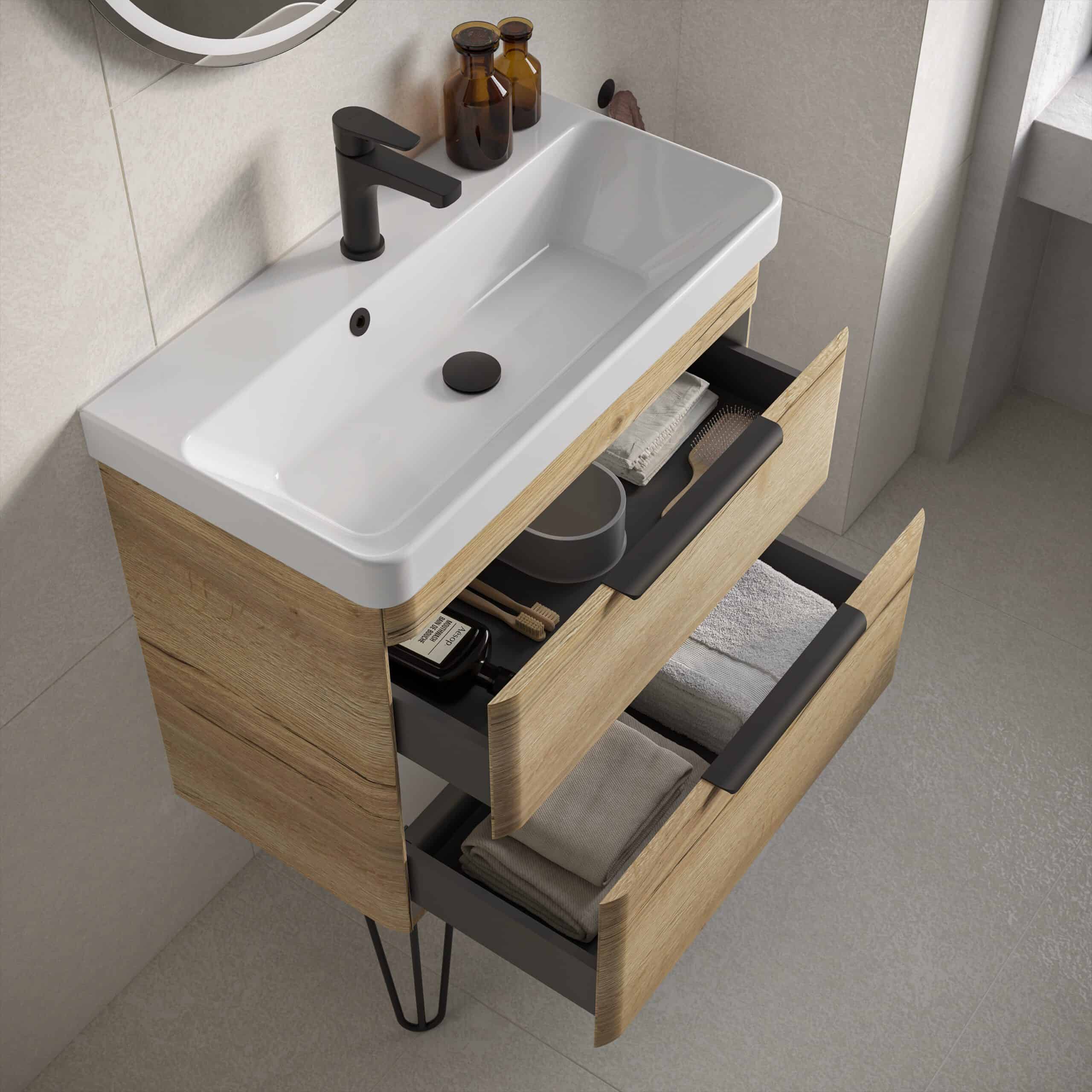 Vanity bathroom cabinet with integrated sink and modern black tap, featuring open drawers with neatly stored towels and personal care items, in a contemporary bathroom setting.