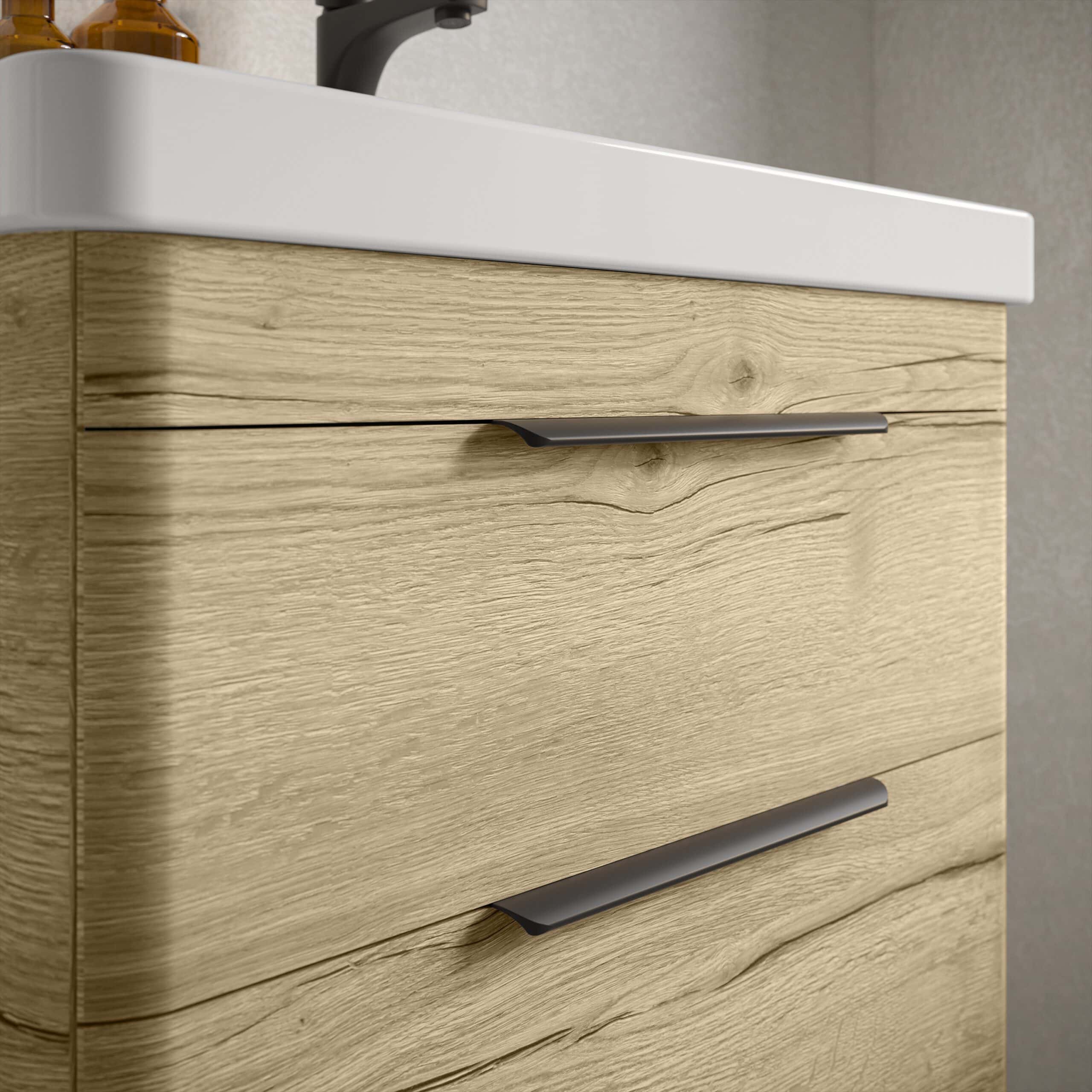 Sleek wooden bathroom vanity with modern silver handles and a white ceramic countertop in a contemporary bathroom setting.