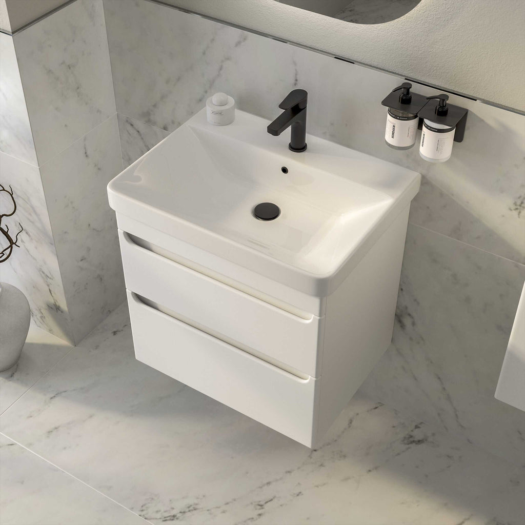 Modern white bathroom vanity with a sleek black tap and storage drawers, set against marble wall and floor, perfect for contemporary bathrooms.