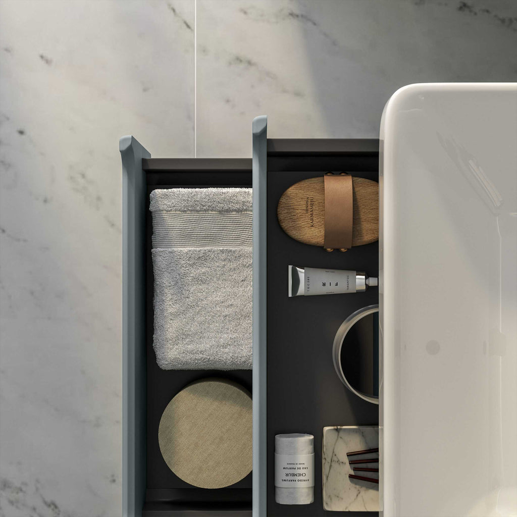 Pristine bathroom drawer organiser with towel, soap, skincare products, and accessories in a modern bathroom setting.