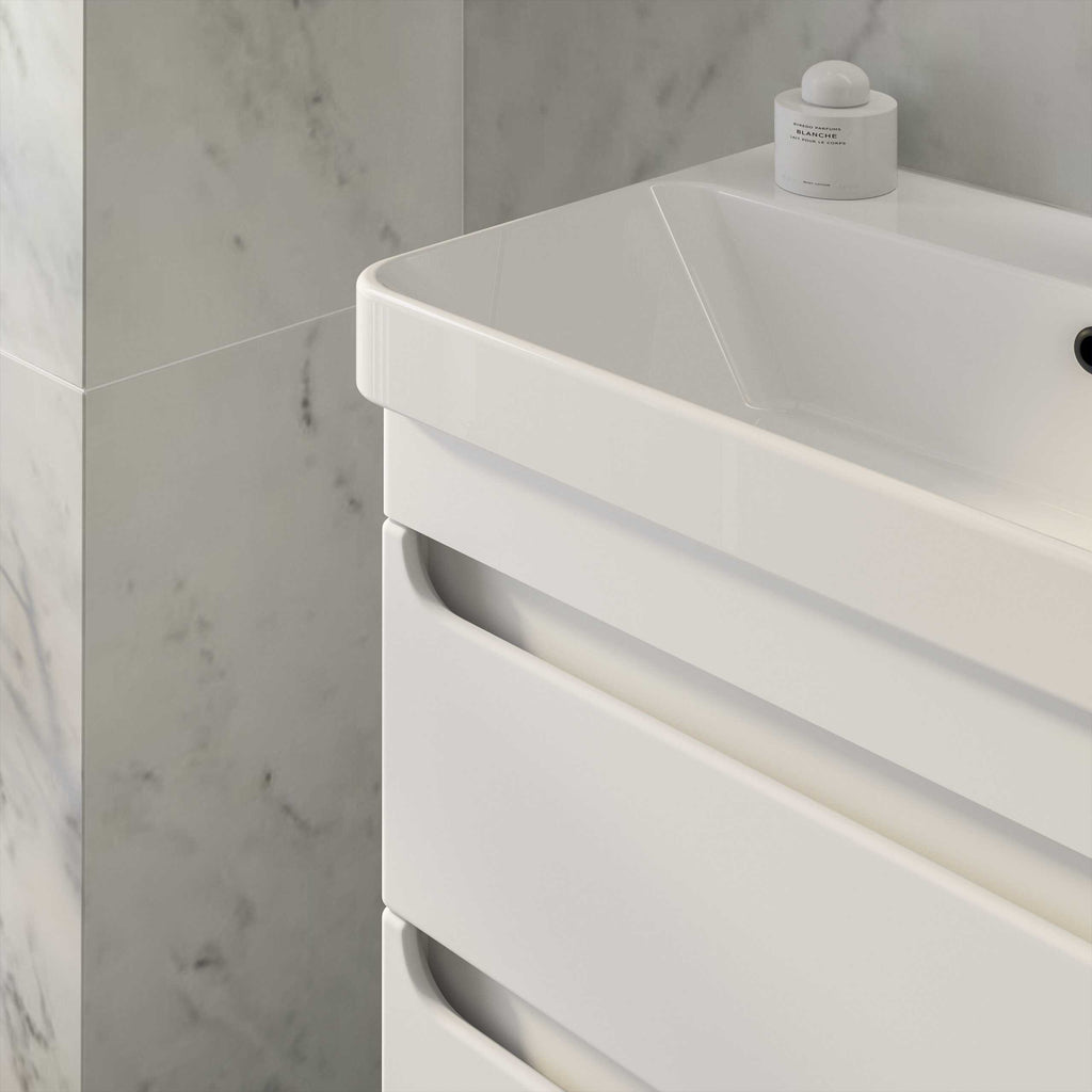 Sleek white bathroom vanity with integrated drawers in a modern style, positioned against a marble tiled wall, showcasing elegant bathroom furniture.