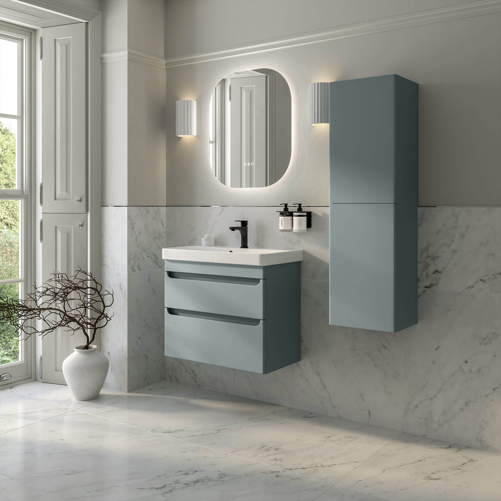 Modern blue bathroom vanity with integrated sink and wall-mounted storage cabinet, set against marble tiled walls and flooring, illuminated by contemporary wall sconces.
