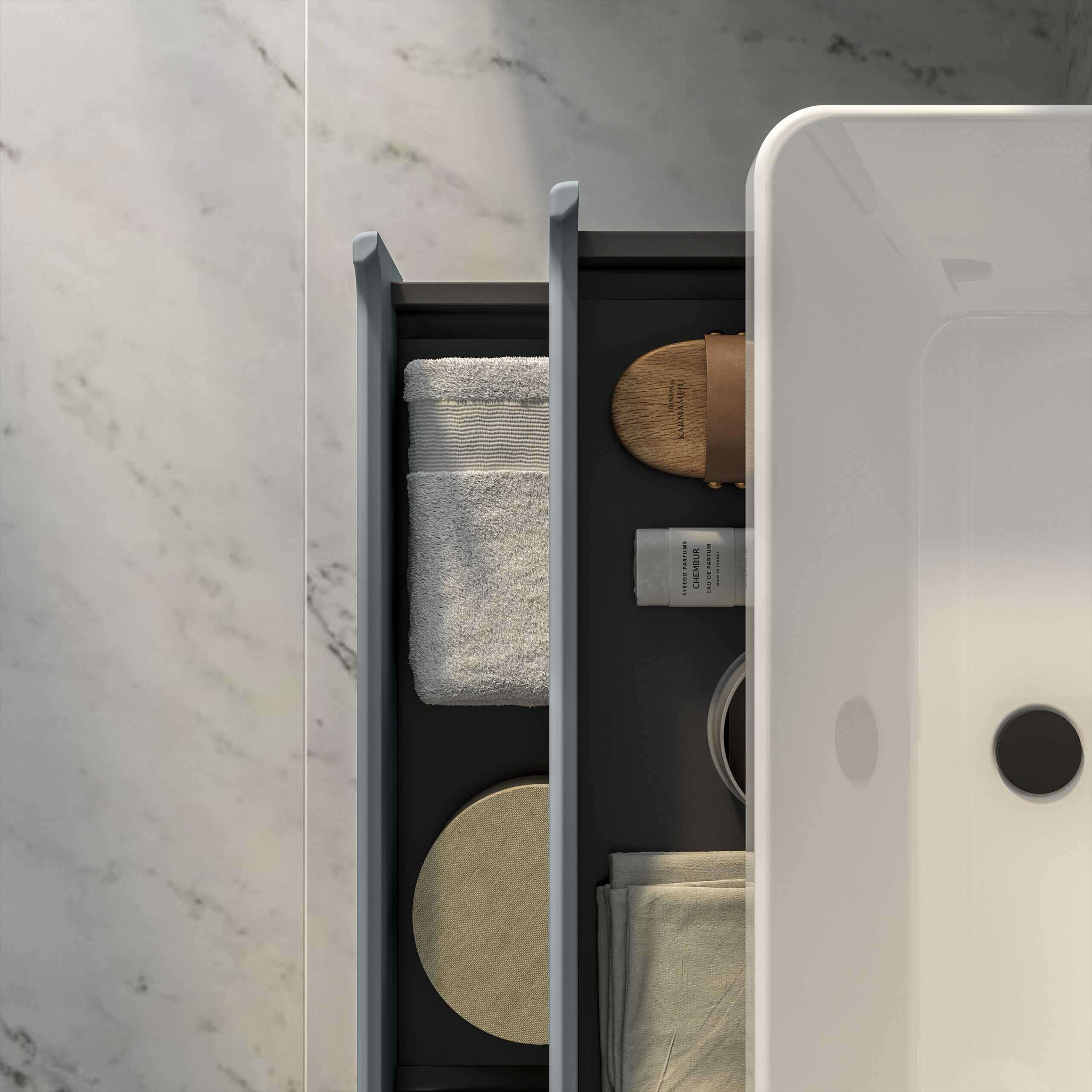 Neatly organised bathroom drawer with towels, toiletries, and accessories for modern bathroom storage solutions.