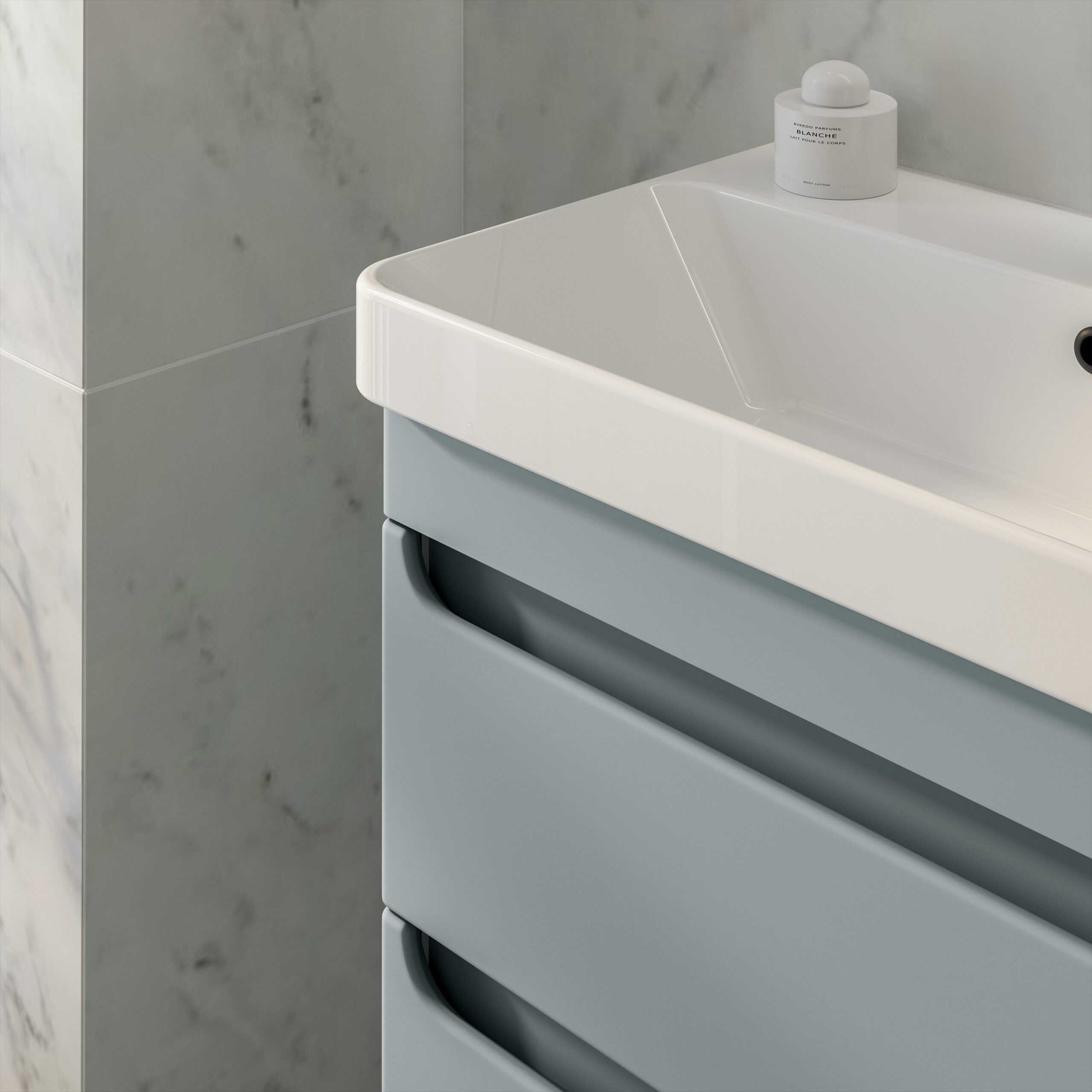 Modern white bathroom sink with grey drawers and marble wall tiles, showcasing sleek design and contemporary bathroom fixtures for stylish and functional bathroom remodels.
