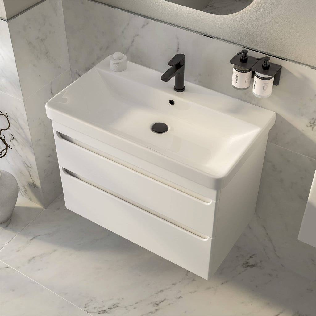 Minimalist white bathroom vanity with black faucet and integrated sink, featuring spacious drawers for storage, against a marble wall background, perfect for modern Bubly Bathrooms.