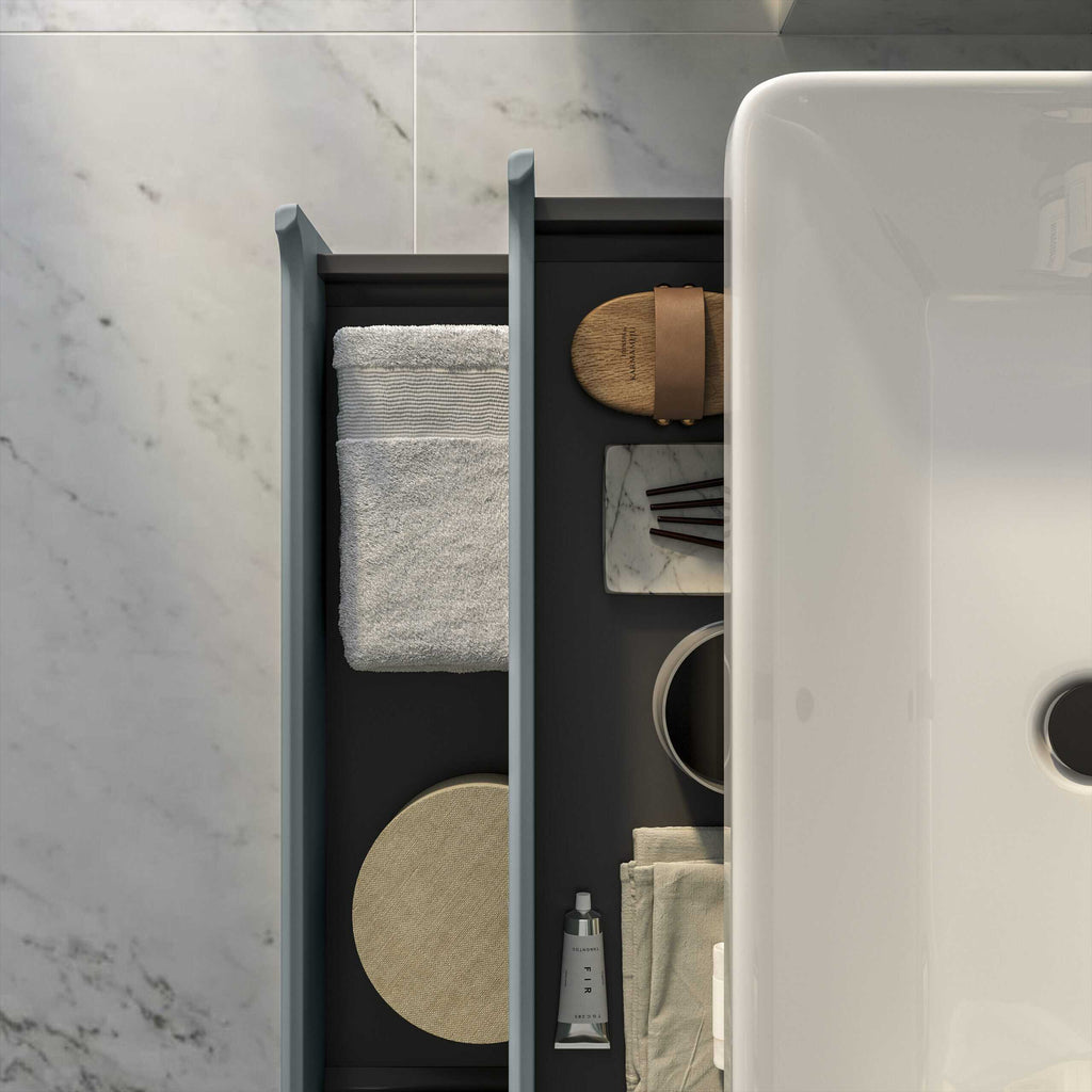 Luxurious bathroom storage with towels, accessories and toiletries arranged neatly beside a modern white bathtub in a minimalist bathroom design.