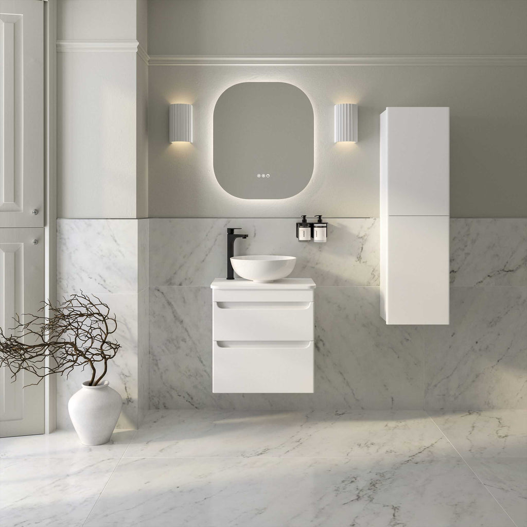 Modern minimalistic bathroom vanity with white wall-mounted cabinet and vessel sink, black faucet, and stylish oval mirror, featuring sleek design and marble tiles, ideal for contemporary Bubly Bathrooms.