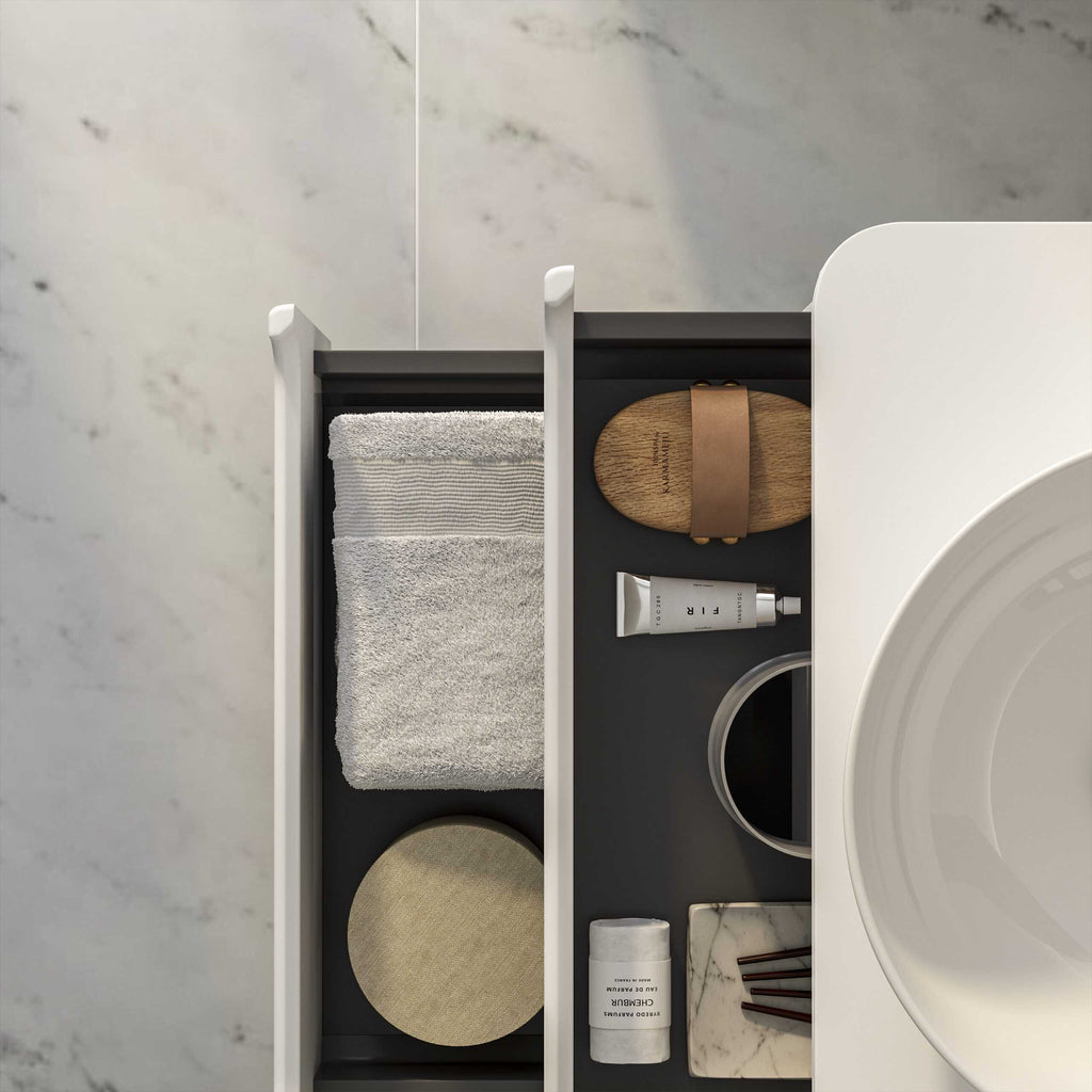 Neatly organised bathroom drawer with towels, skincare products, and accessories, showcasing modern bathroom storage solutions.