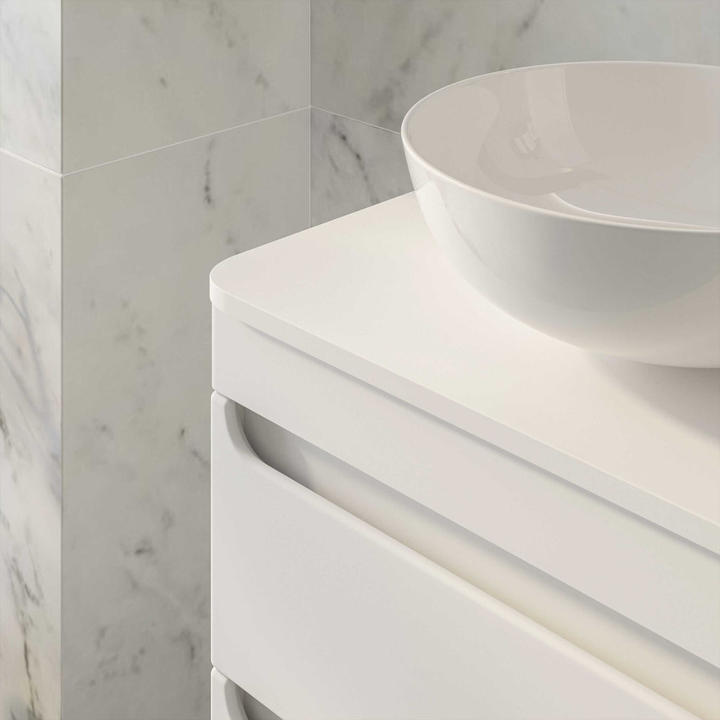 Sleek white bathroom vanity with a modern circular ceramic basin, set against a marble-tiled wall, perfect for contemporary bathroom design and stylish storage solutions.