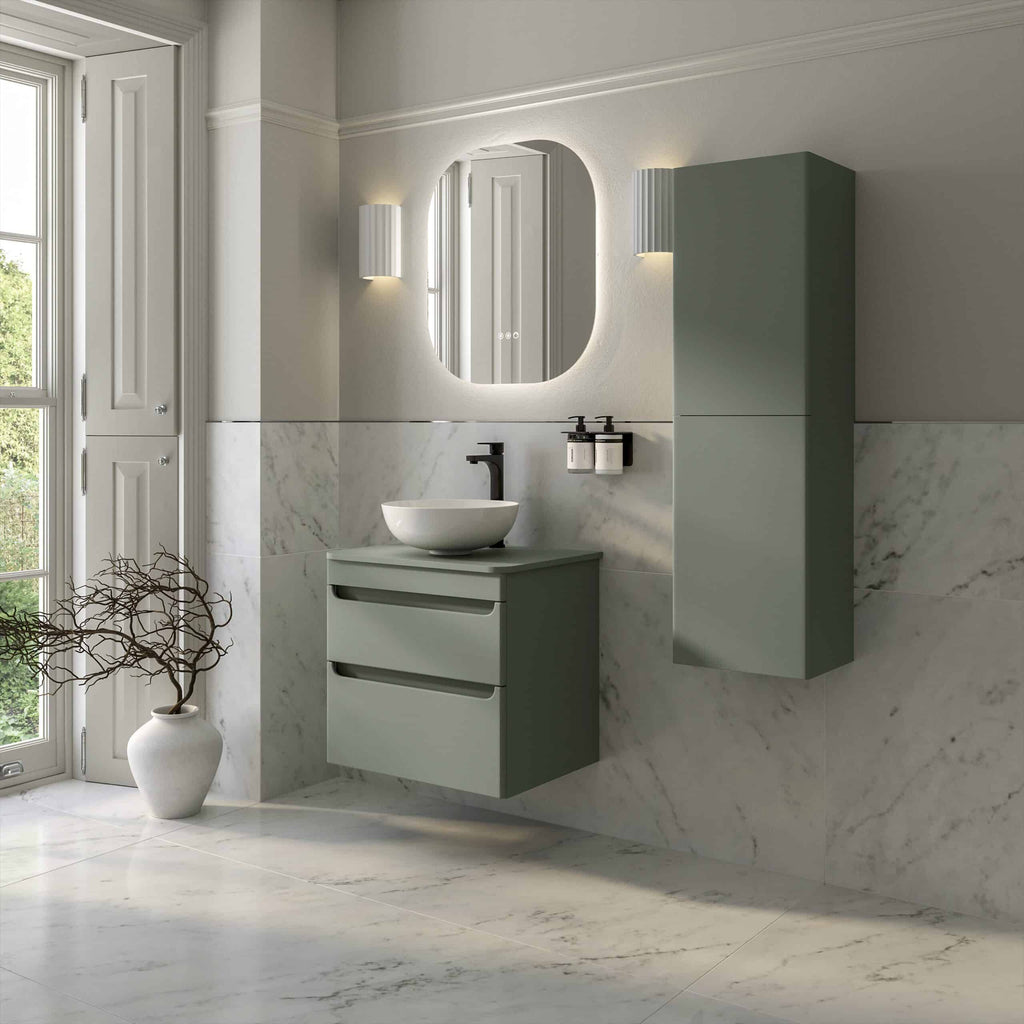 Miniature green wall-mounted bathroom cabinet with integrated sink, modern black faucet, and matching mirror with backlit lighting in a minimalist bathroom setting.