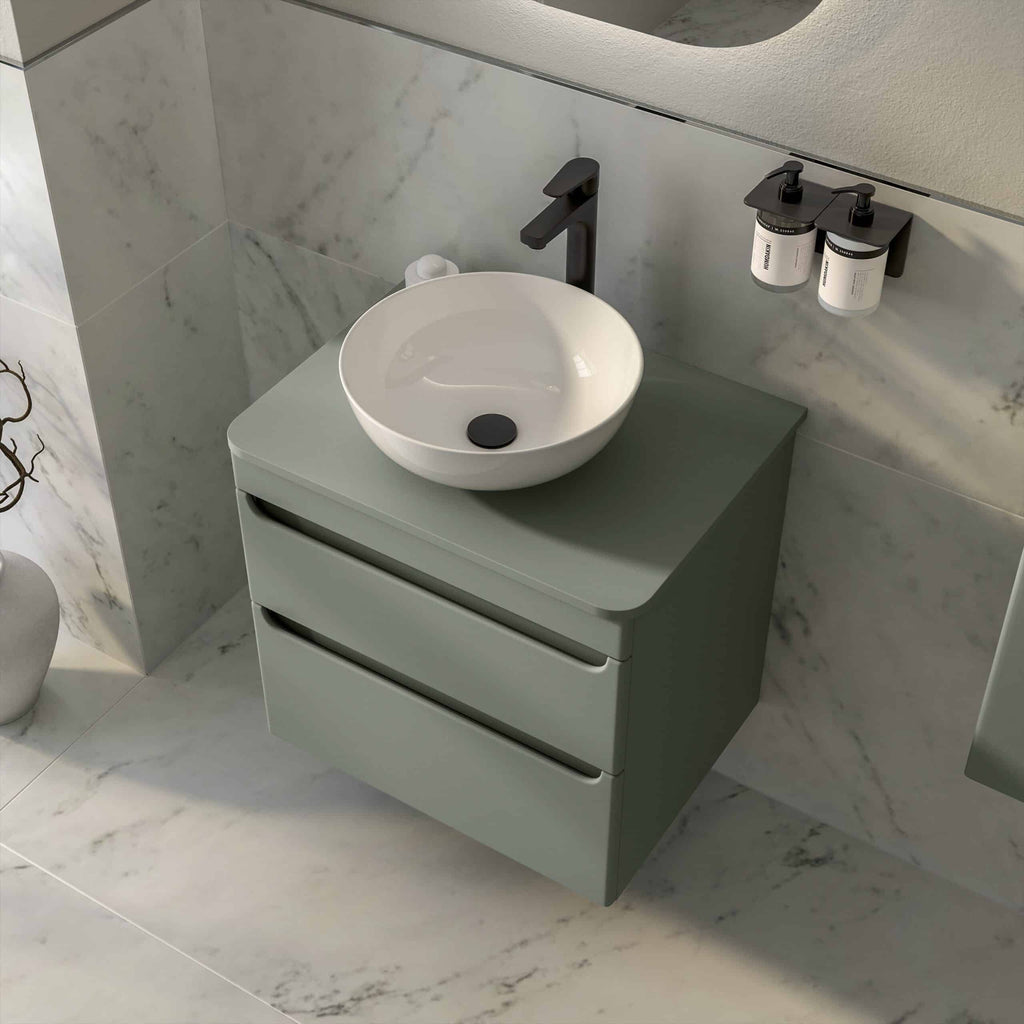 Contemporary bathroom vanity with a round vessel sink, matte black tap and wall-mounted storage, set against marble walls and floors for a sleek, modern look.