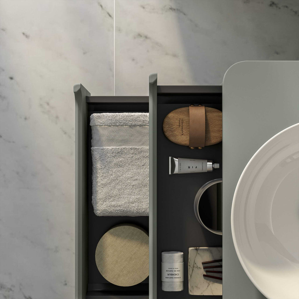 Neat bathroom organising drawer with essentials including skincare, towels, marble coaster, and wooden soap dish, showcasing elegant bathroom storage solutions.