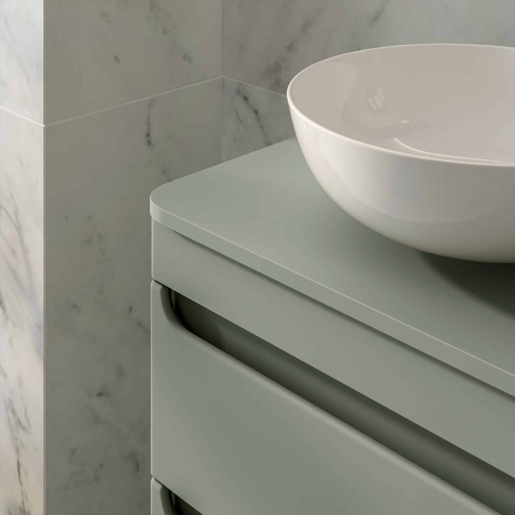 Sleek modern bathroom vanity with matte grey finish and rounded handle design, topped with stylish white vessel sink, set against marble tiled wall for contemporary bathroom decor.