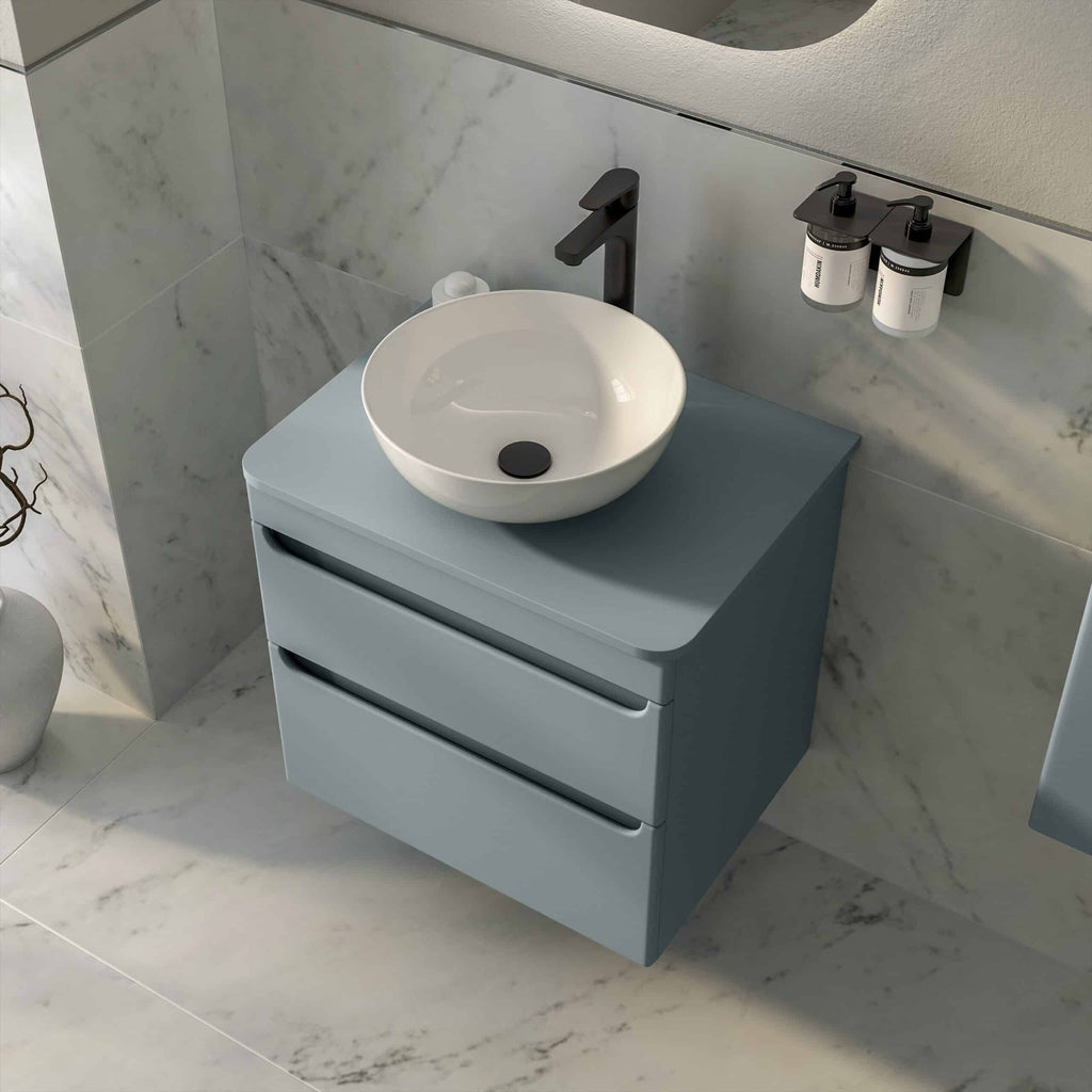 Sleek blue bathroom vanity with a modern round white vessel sink, black faucet, and matching soap dispensers, creating a contemporary and stylish bathroom design.
