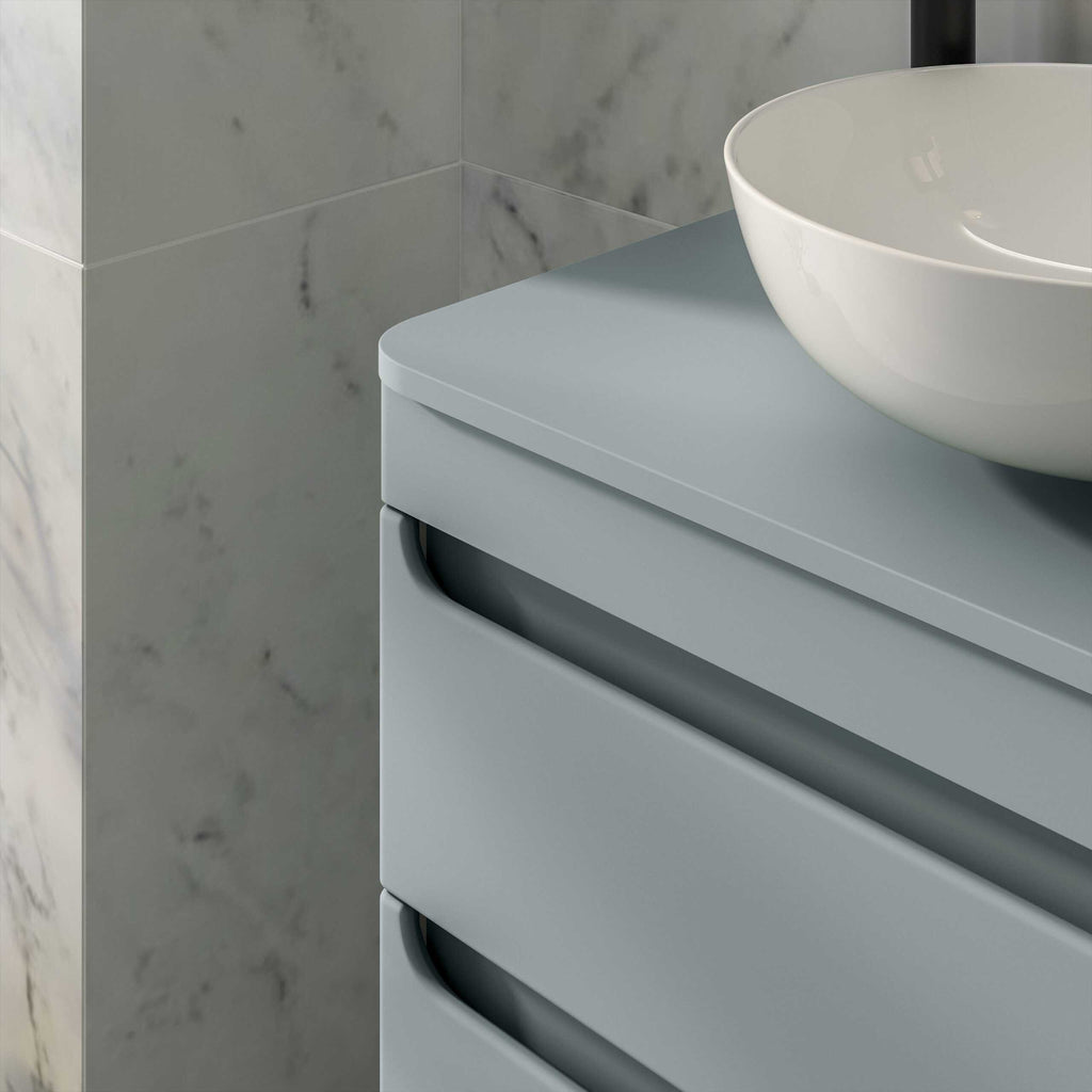 Modern bathroom vanity unit with a vessel sink, grey finish, and marble wall tiles for contemporary bathroom design.
