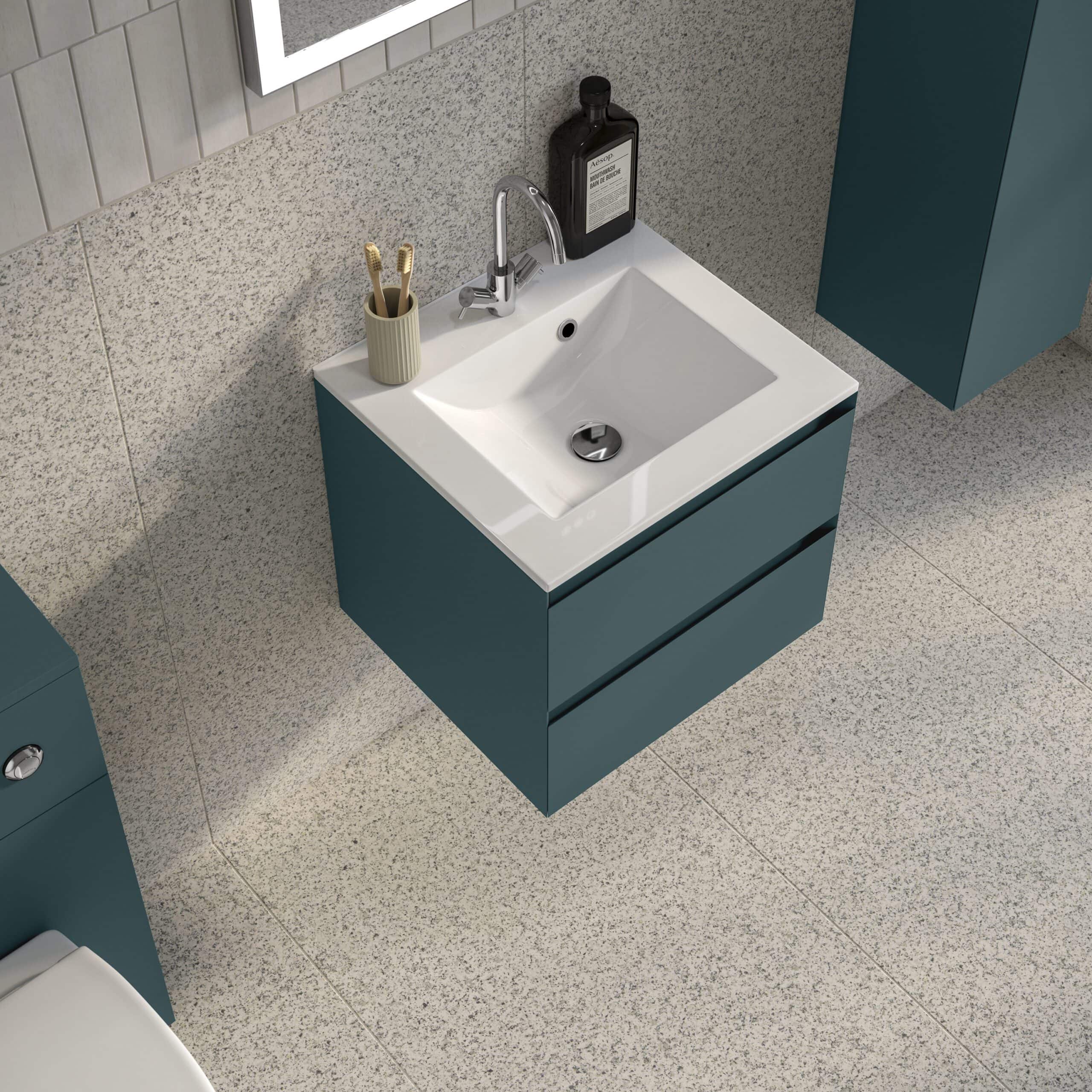 Contemporary blue bathroom vanity with integrated sink, chrome faucet, toothbrush holder, and bathroom essentials, set against textured tile flooring and wall for a modern bathroom look.