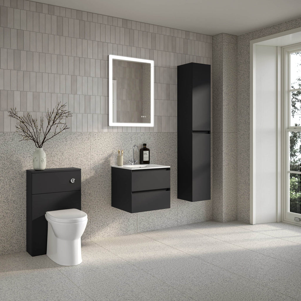 Modern black bathroom furniture with a wall-mounted vanity, tall storage cabinet, and compact toilet, set against a textured tiled wall with a large window for natural light.