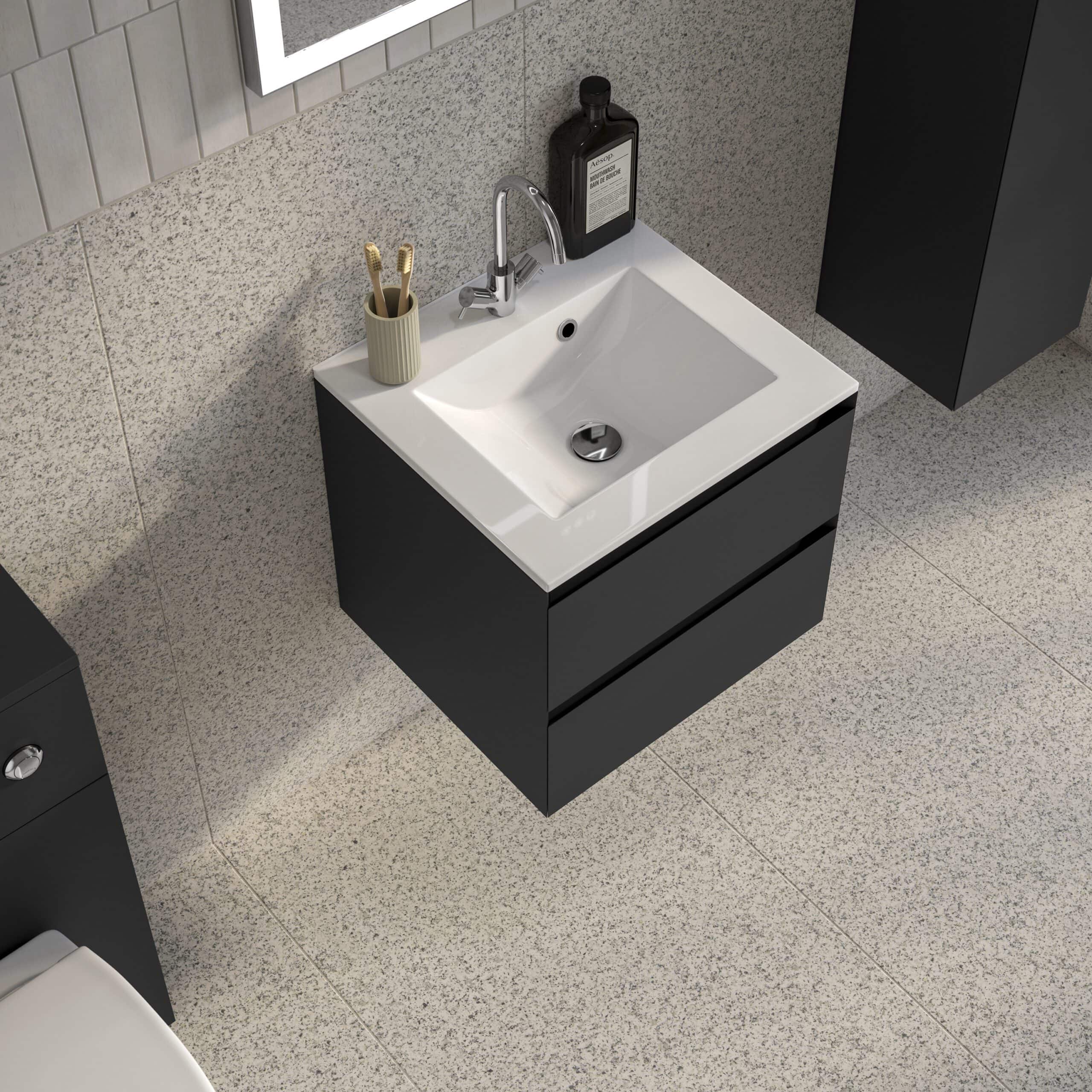 Fitted black bathroom vanity with a white ceramic sink, chrome faucet, toothbrush holder, and black soap dispenser in modern bathroom decor.