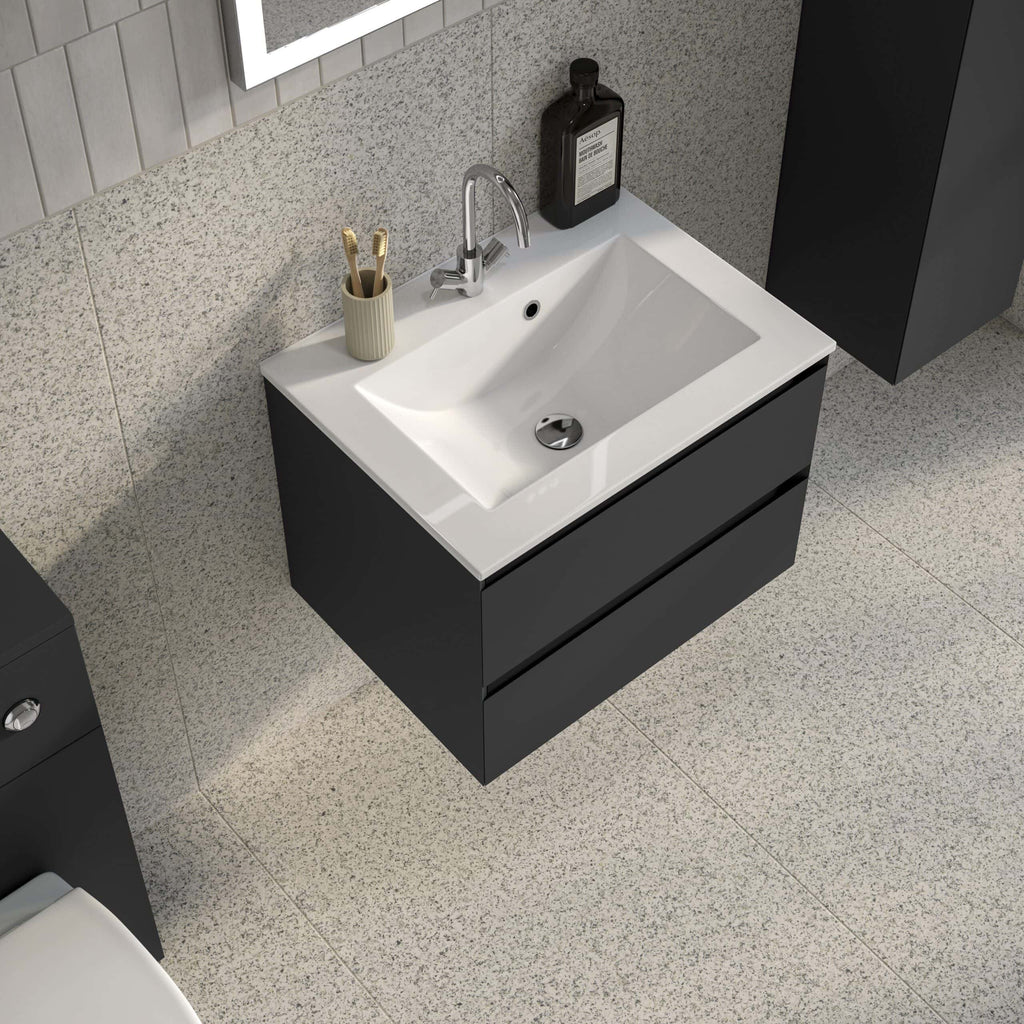 Shiny black bathroom vanity with a white ceramic sink, chrome tap, and bathroom essentials like toothbrushes and hand wash on the countertop, in a modern bathroom setting.