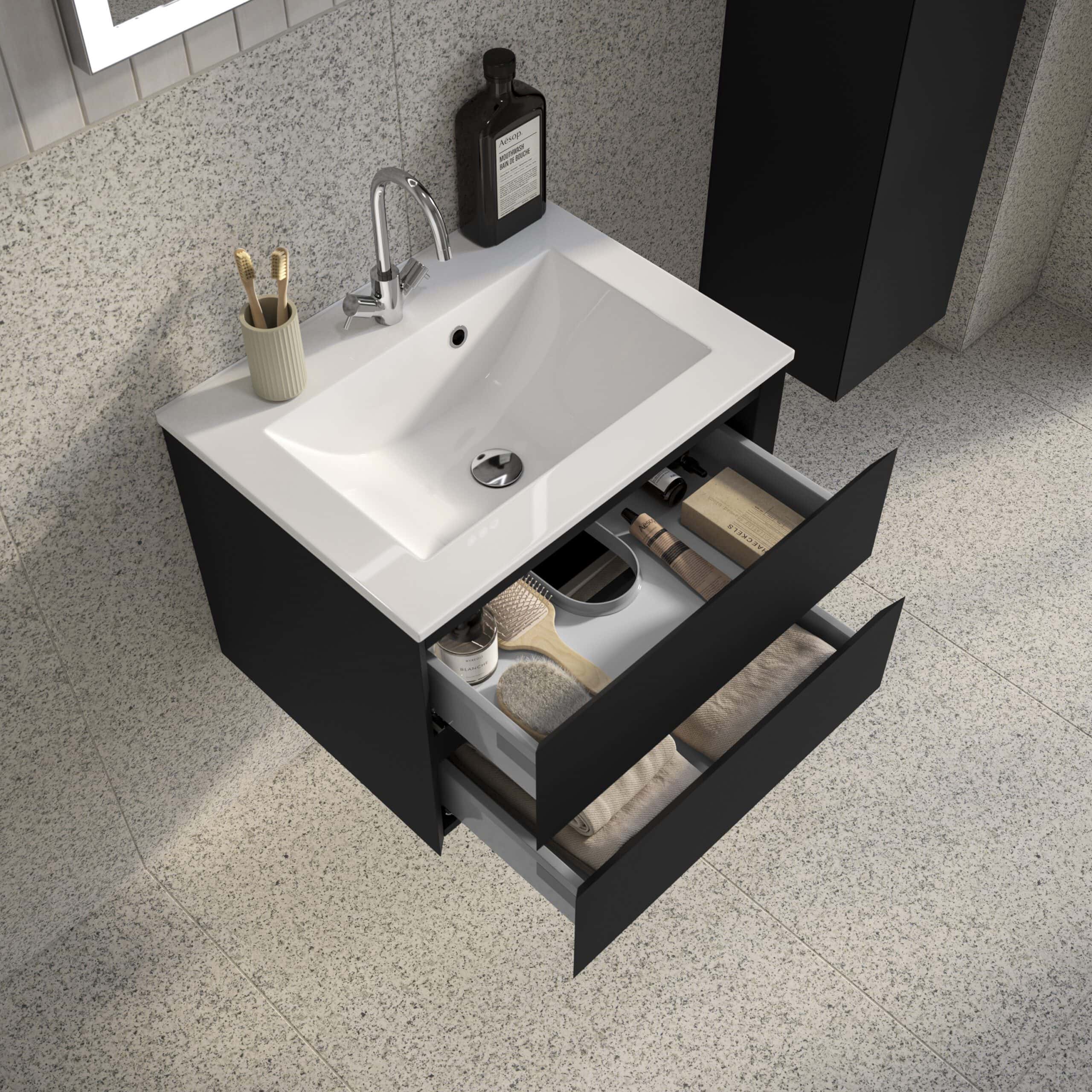Sleek black bathroom vanity with white countertop and integrated sink, featuring open drawers with organised toiletries, ideal for modern bathroom storage and design.