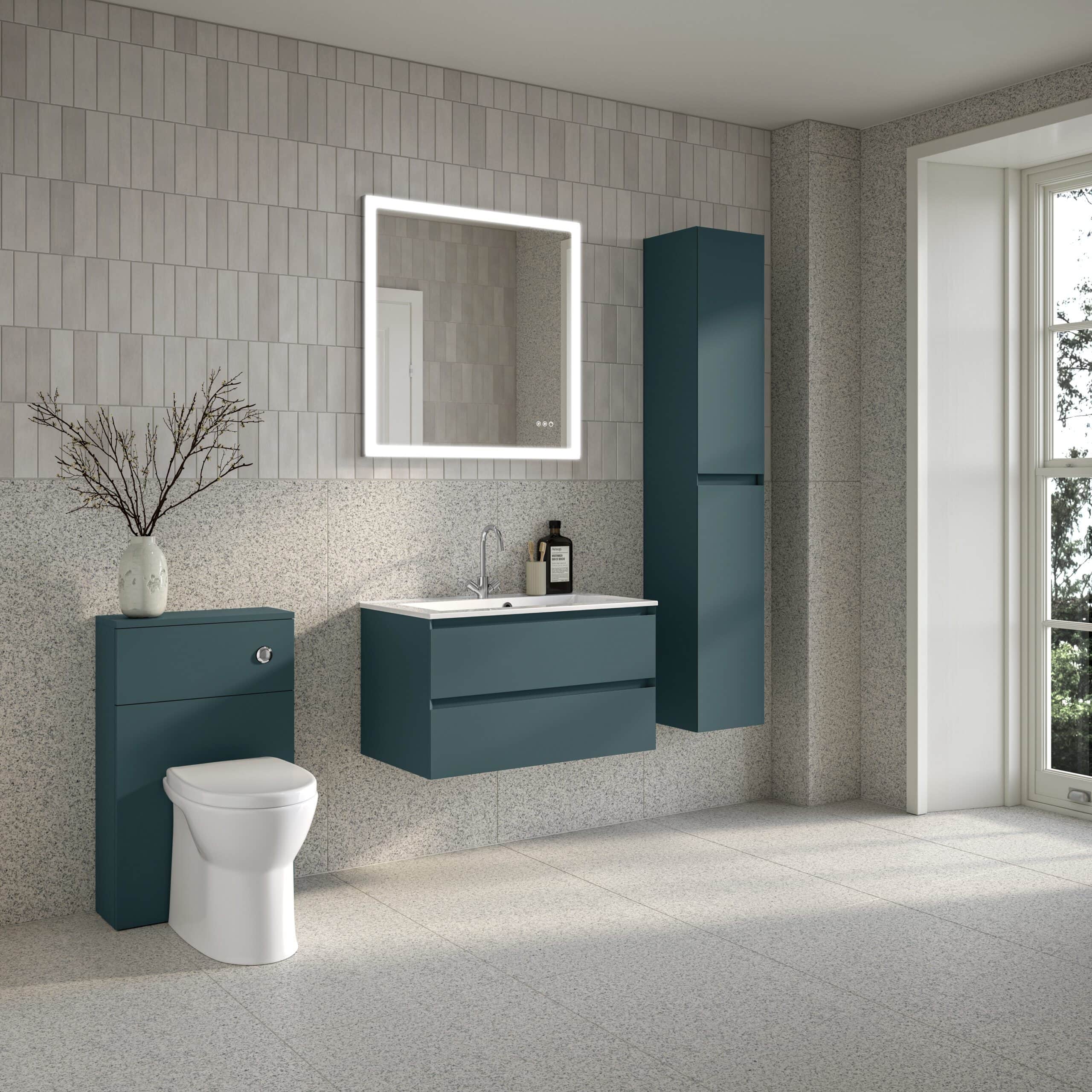Contemporary blue bathroom vanity set with wall-mounted cabinet, mirror with LED lighting, and toilet in a modern, minimalistic bathroom design featuring textured tiles and large window for natural light.