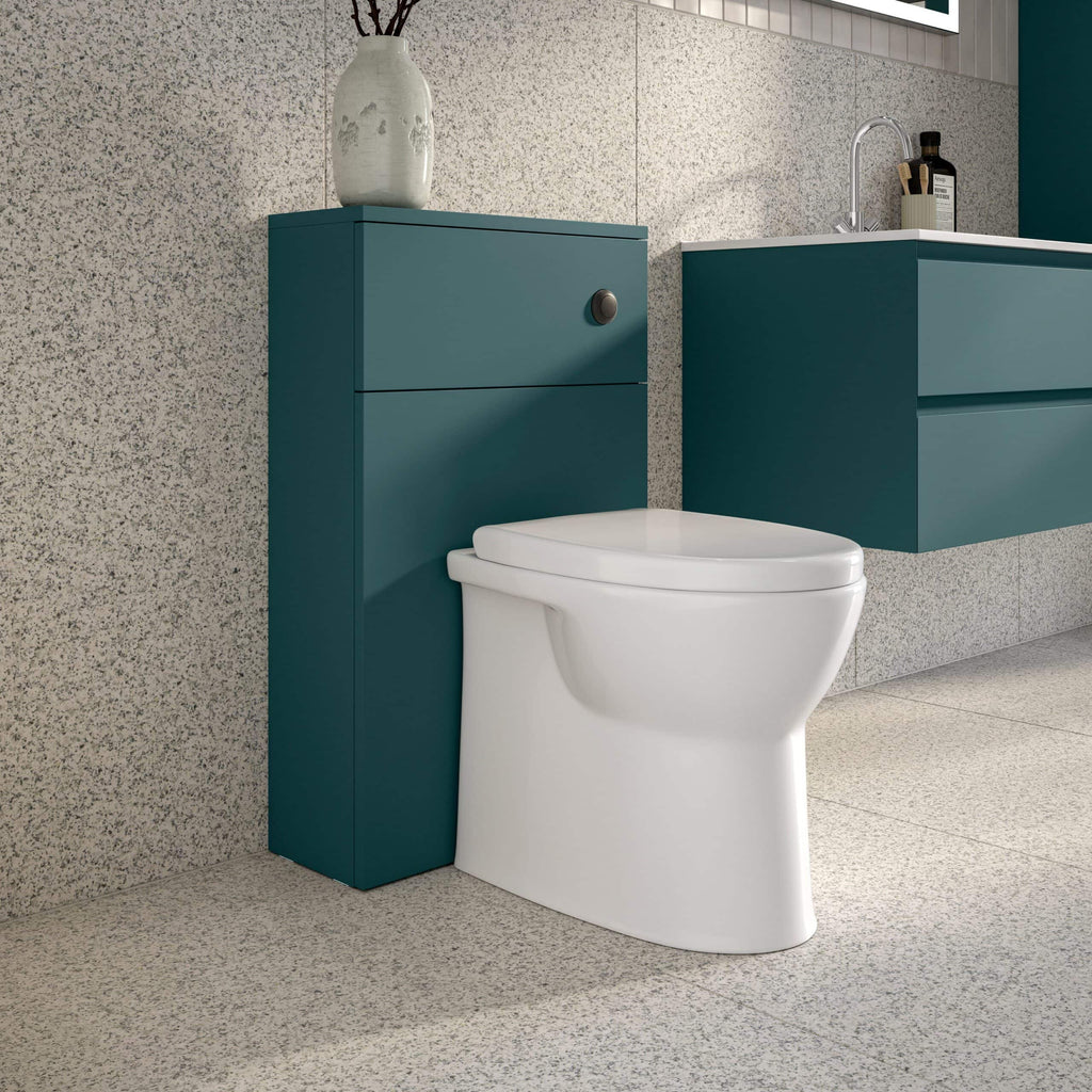 Contemporary bathroom with modern toilet, teal storage unit, and sleek wall-mounted vanity with sink, featuring minimalist design and stylish decor.