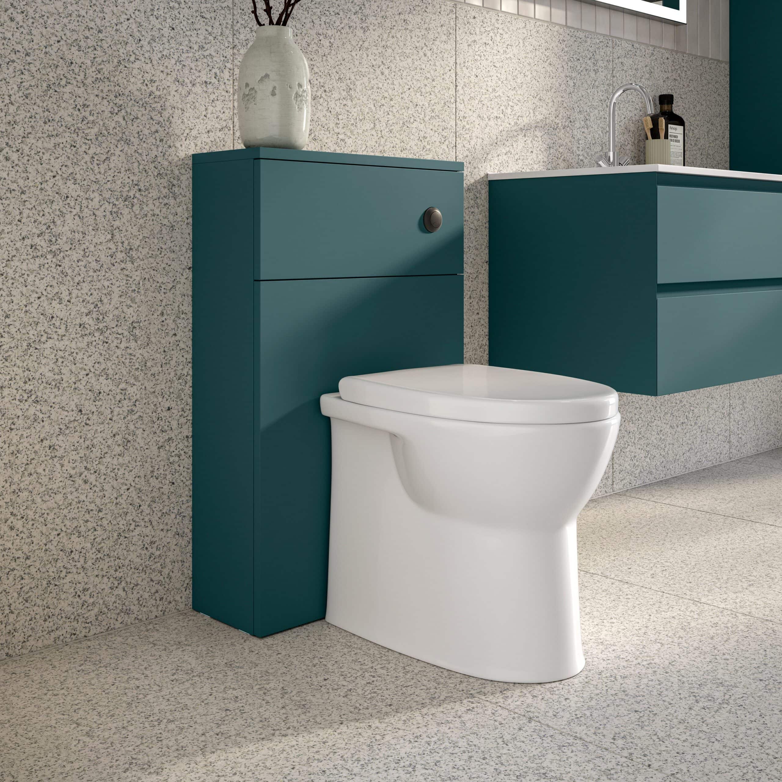 Contemporary bathroom with modern toilet, teal storage unit, and sleek wall-mounted vanity with sink, featuring minimalist design and stylish decor.