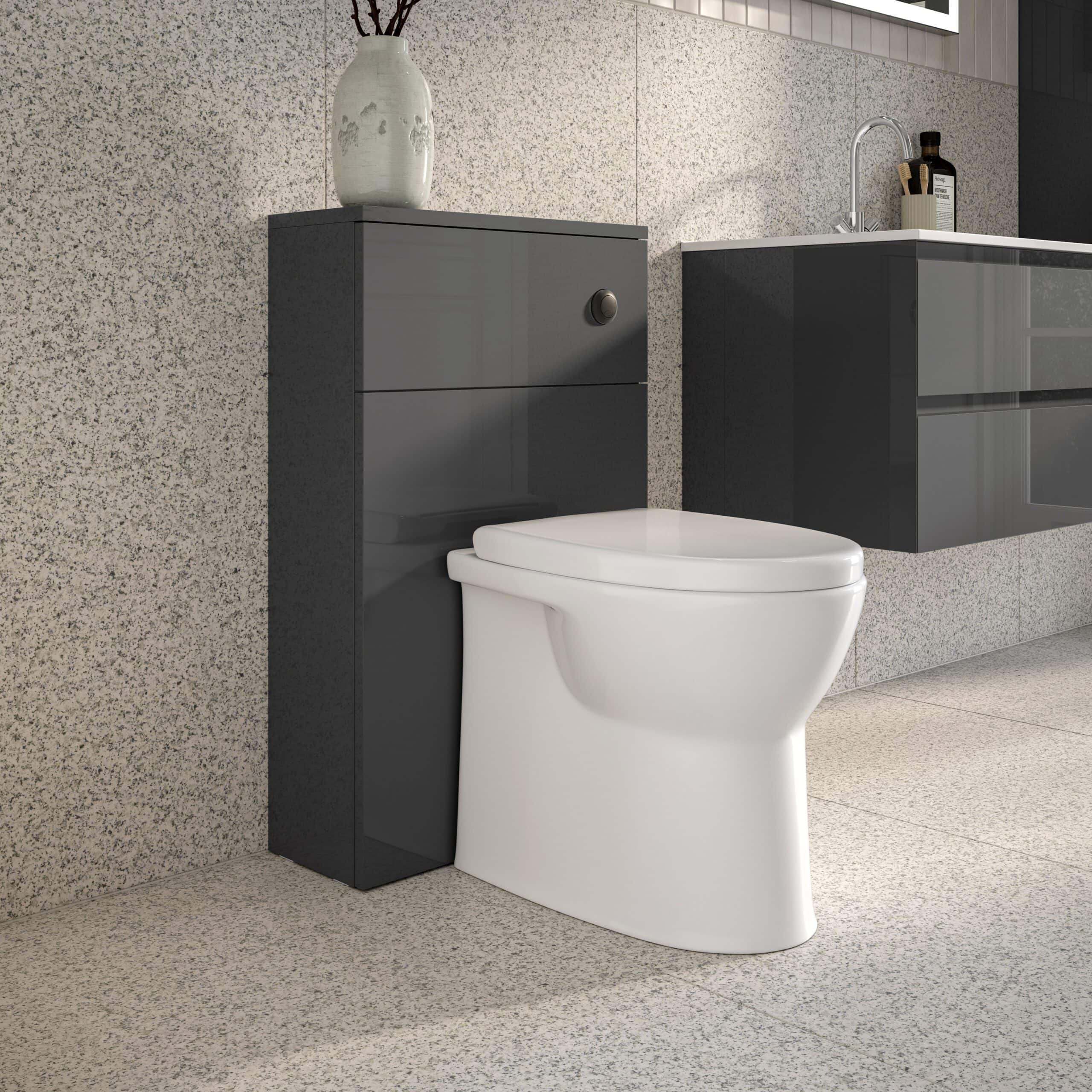Modern white toilet with sleek grey bathroom cabinet and minimalist design, set against textured stone walls, showcasing contemporary bathroom fixtures and storage solutions.