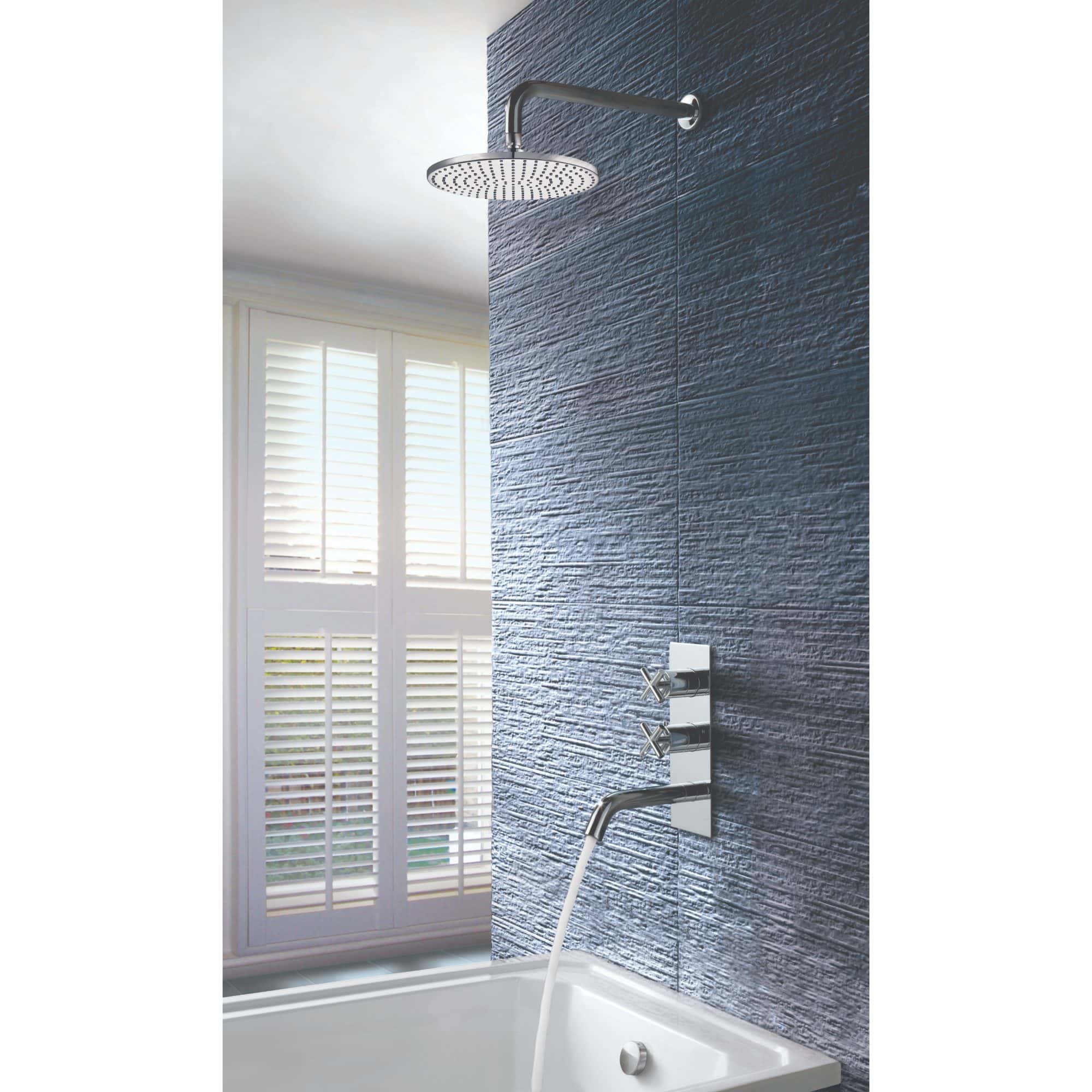 Modern bathroom shower with sleek chrome fixtures, textured navy wall tiles, and natural light from white plantation shutters.