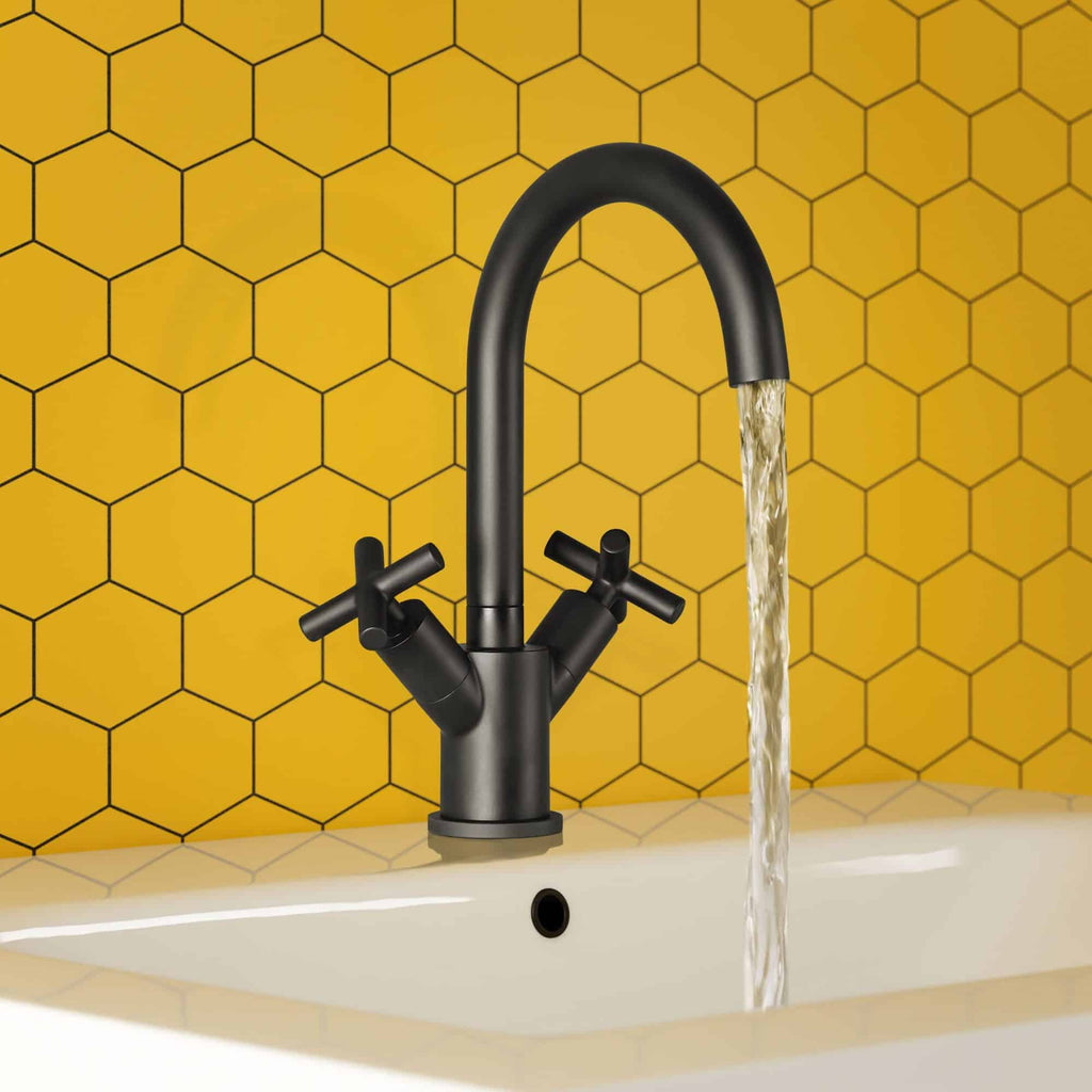 Sleek black kitchen tap with modern mixer design on a white sink, pouring water, against a vibrant yellow honeycomb tile backsplash, ideal for contemporary bathroom or kitchen upgrades.