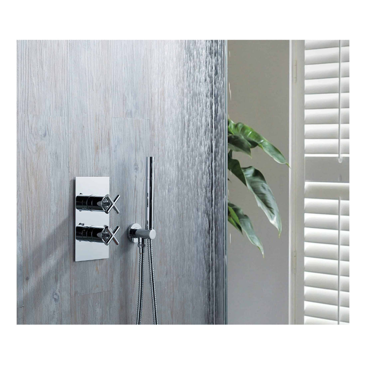 Modern chrome shower mixer with dual controls and handheld shower, installed on a textured grey wall in a contemporary bathroom setting. Ideal for luxurious and functional shower experiences.