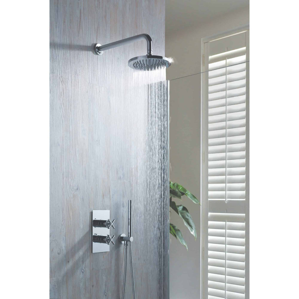 Shower head with rainfall water flow in modern bathroom, chrome fixtures and textured grey wall, near white plantation shutters, contemporary shower design for luxury bathroom detailing.